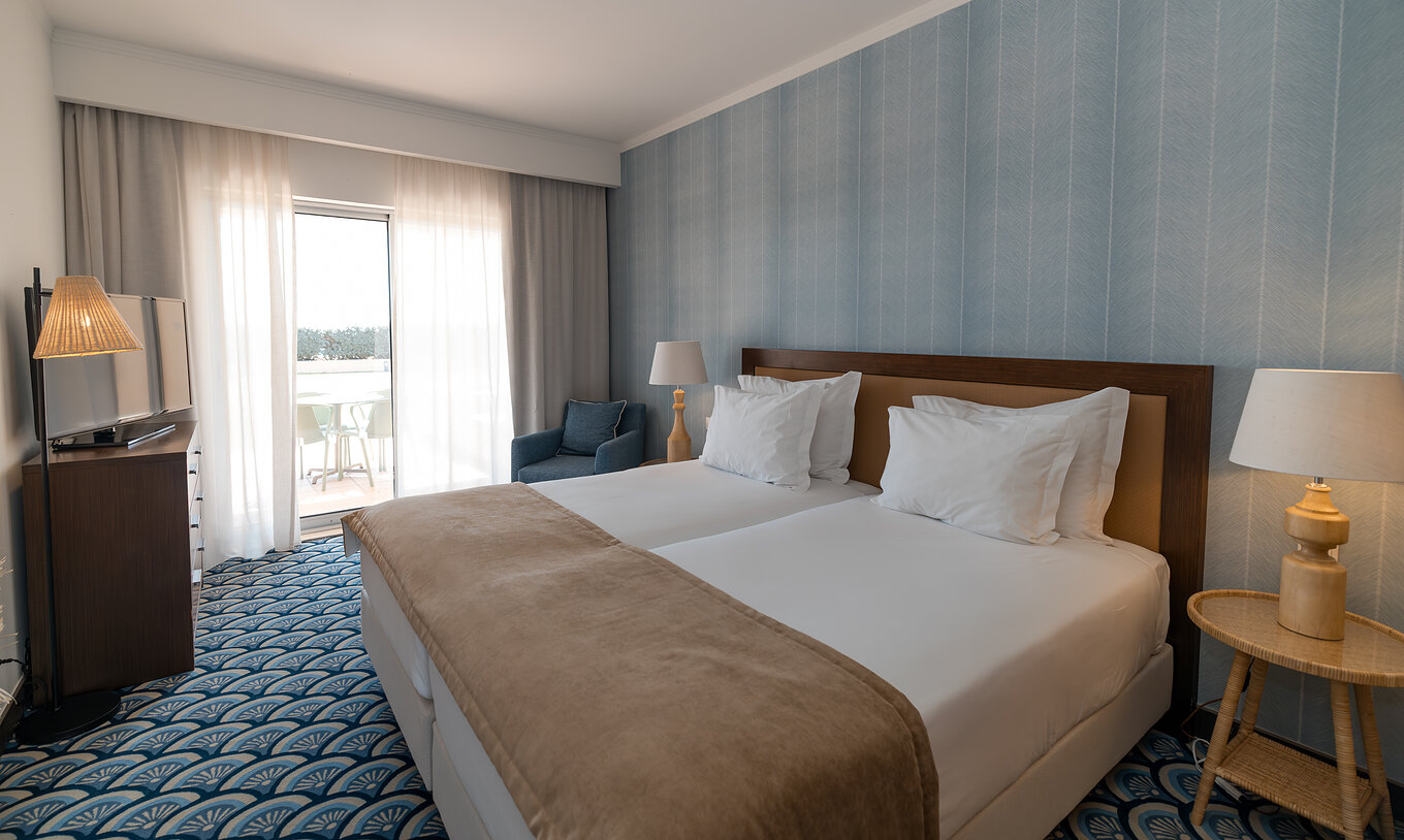 Apartment T1 Garden View at Pestana Alvor Beach Villas has a bedroom with two beds and window with balcony access