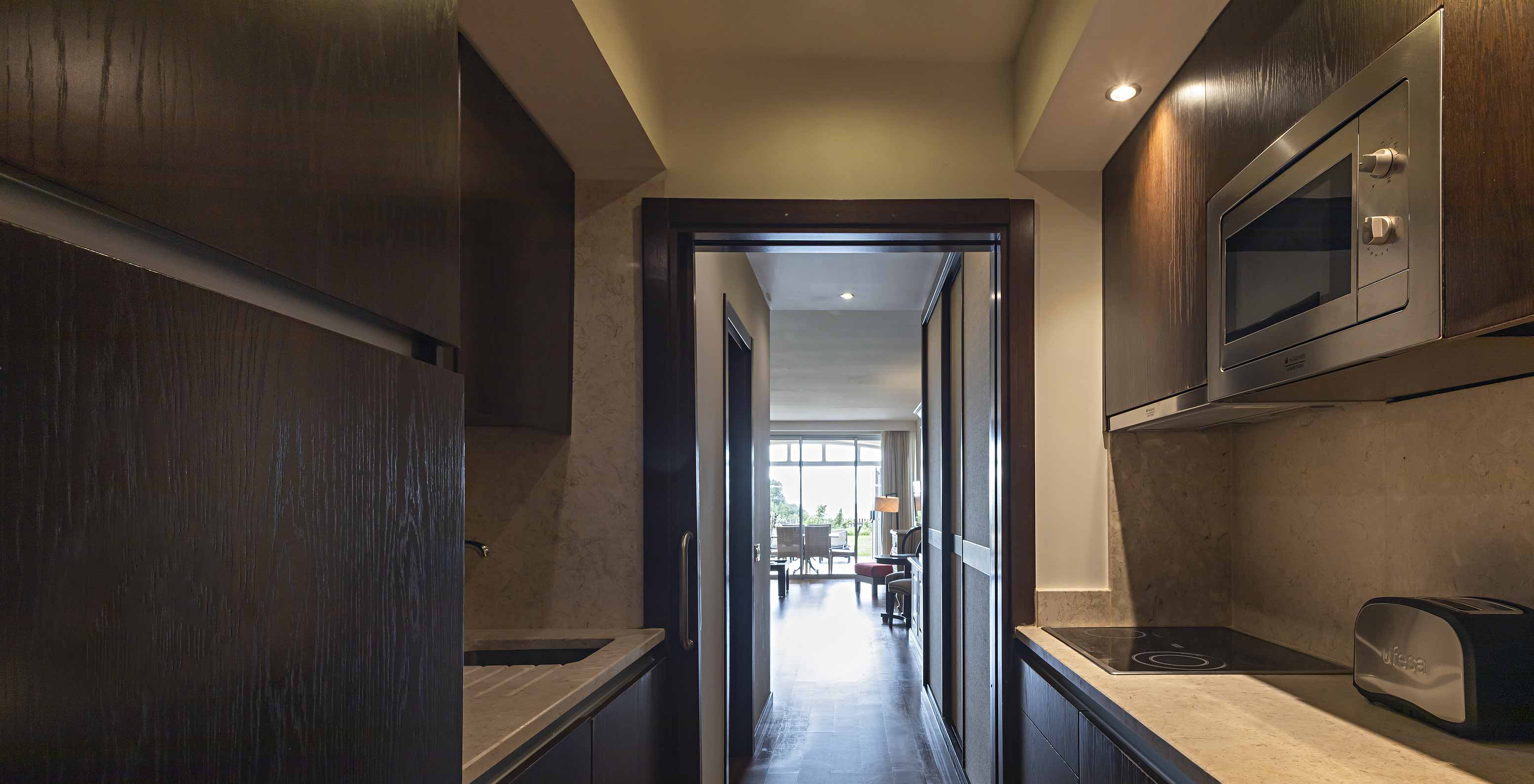 The Cliff Family at Pestana Alvor Praia has a fully equipped kitchen in dark wood and stone, with a stove and a microwave