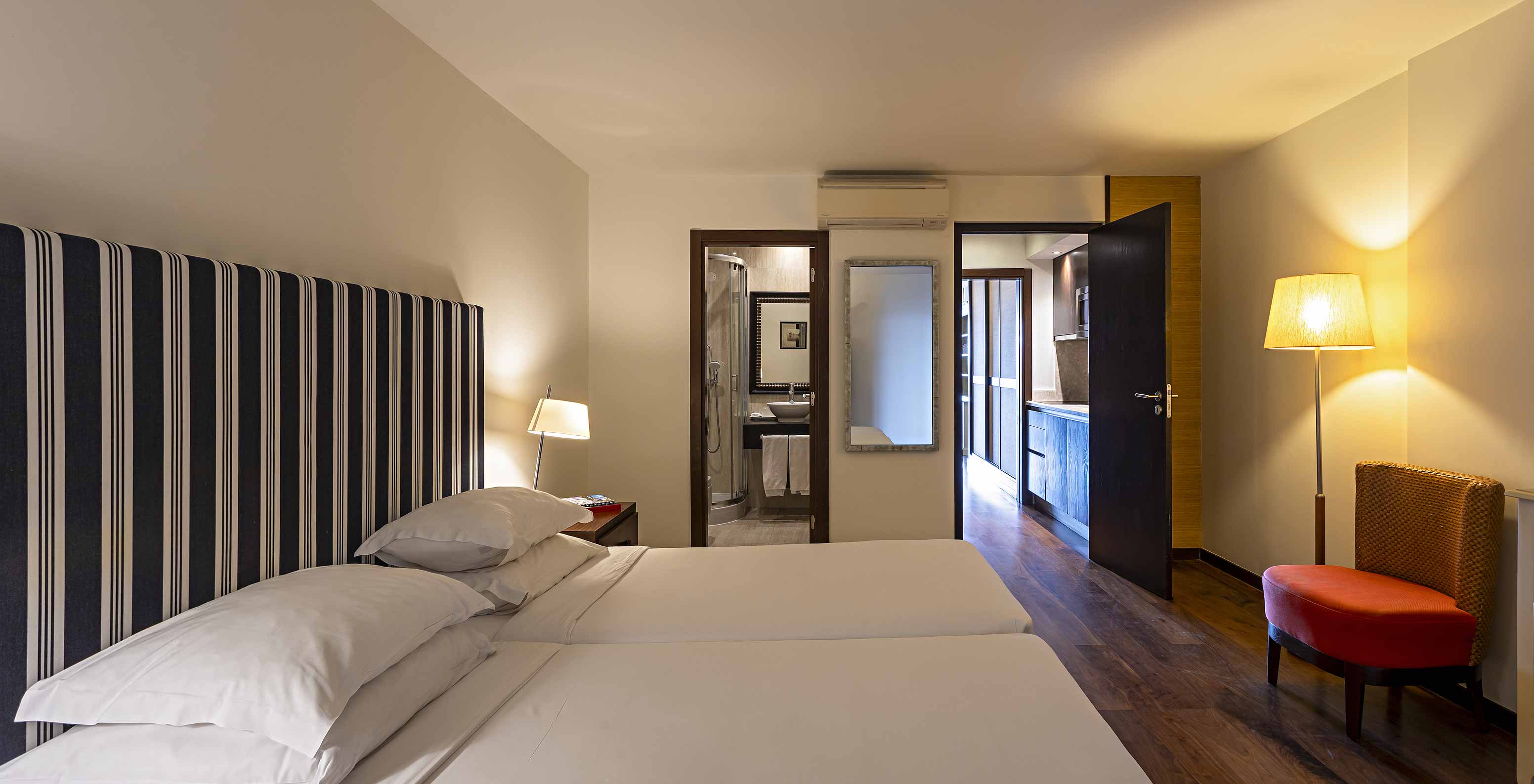 The Cliff Family at Pestana Alvor Praia has a double bedroom with a bathroom, a mirror, and air conditioning