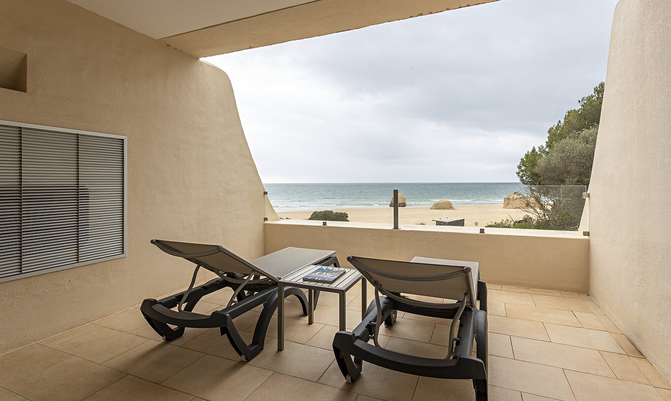 The Cliff Suite T1 at Pestana Alvor Praia has a balcony with two loungers and a view of the beach