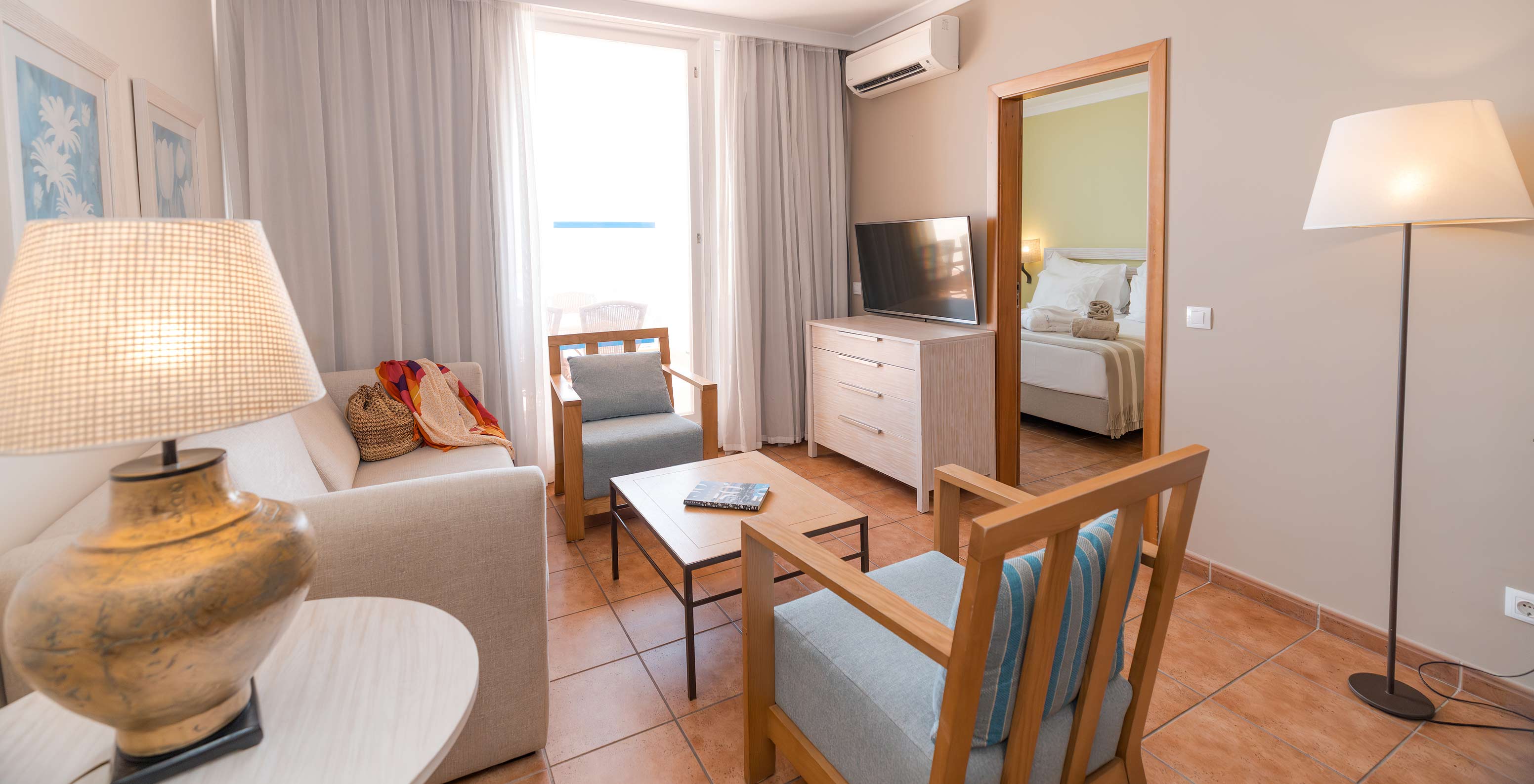 The Superior Sea View Suite at Pestana Viking has a living room with sofa, armchairs, TV, air conditioning and balcony access