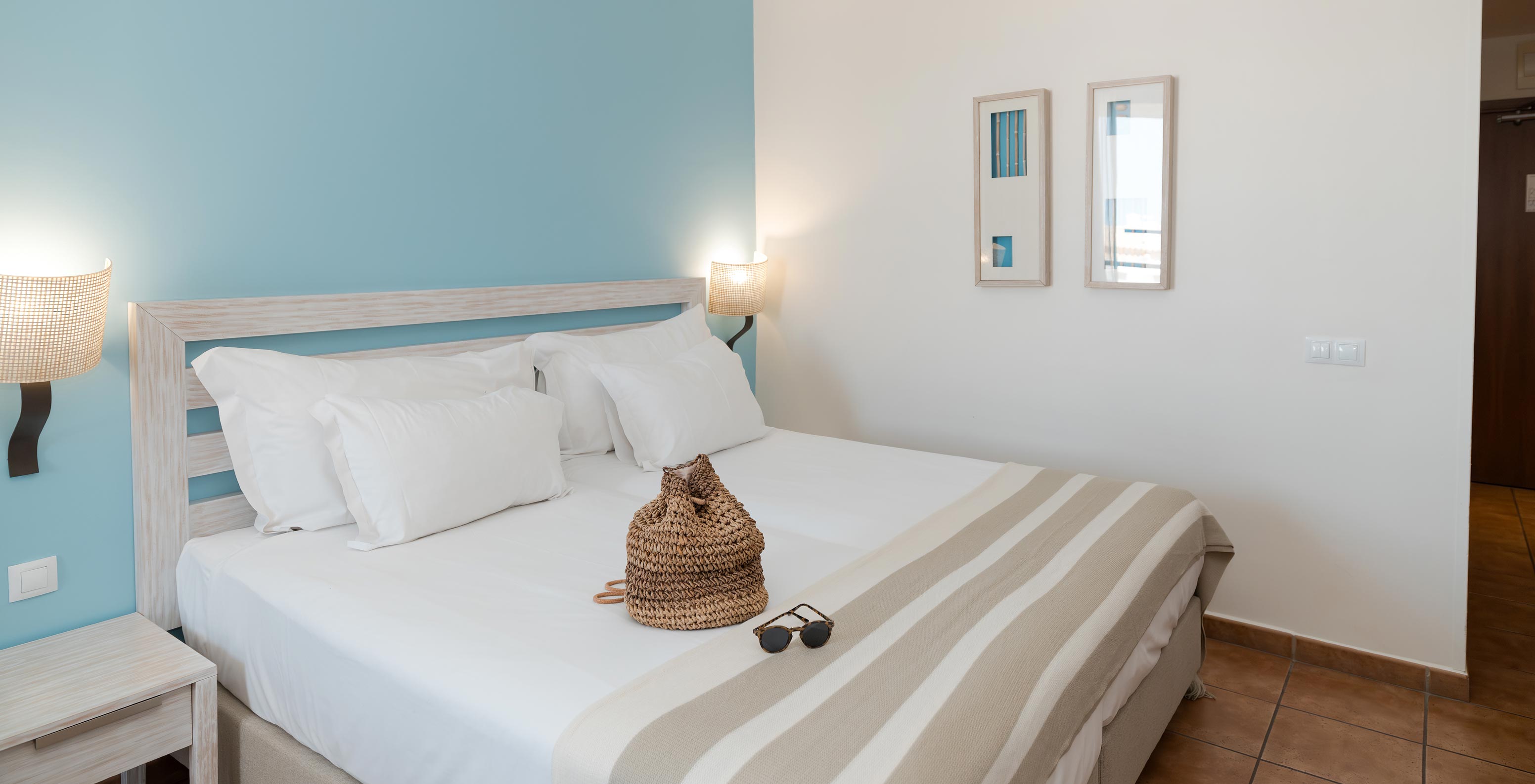 The Deluxe Side Sea View at Pestana Viking has two beds, bedside tables and two pictures on the wall