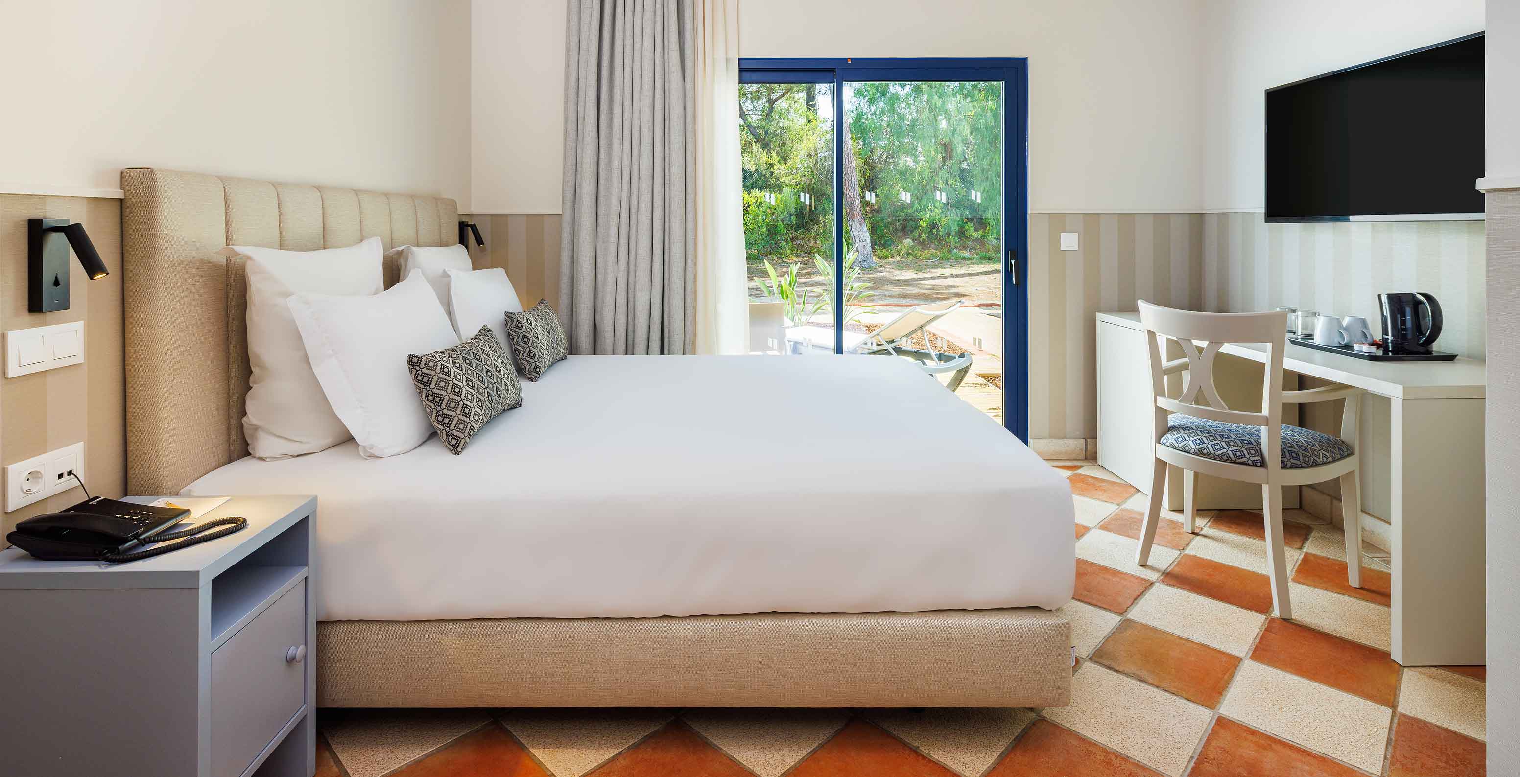 The Classic Garden View at Pestana Vila Sol - Vilamoura has a double bed, desk with chair, and a window with balcony