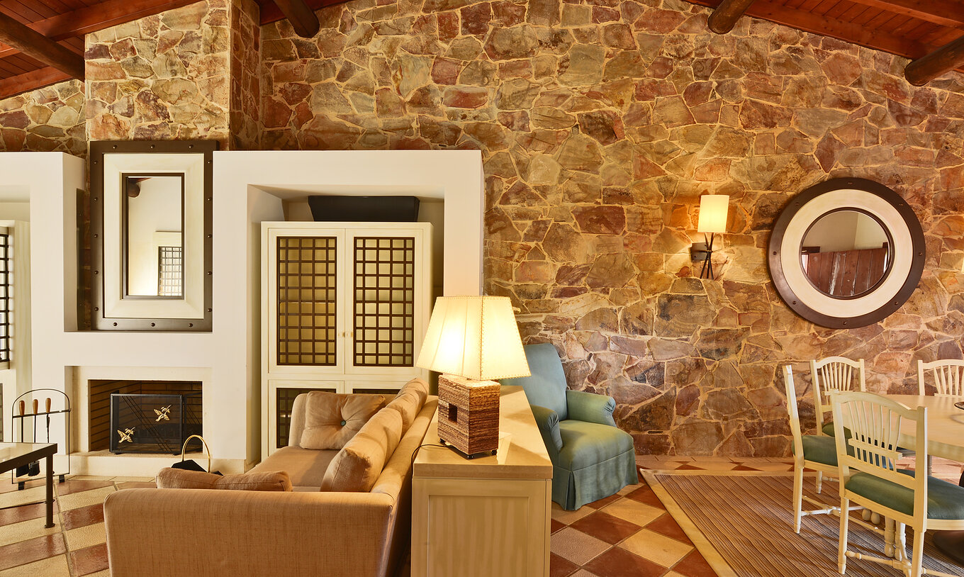 The Garden View Suite at Pestana Vila Sol - Vilamoura has a living room with a sofa, fireplace, and dining table