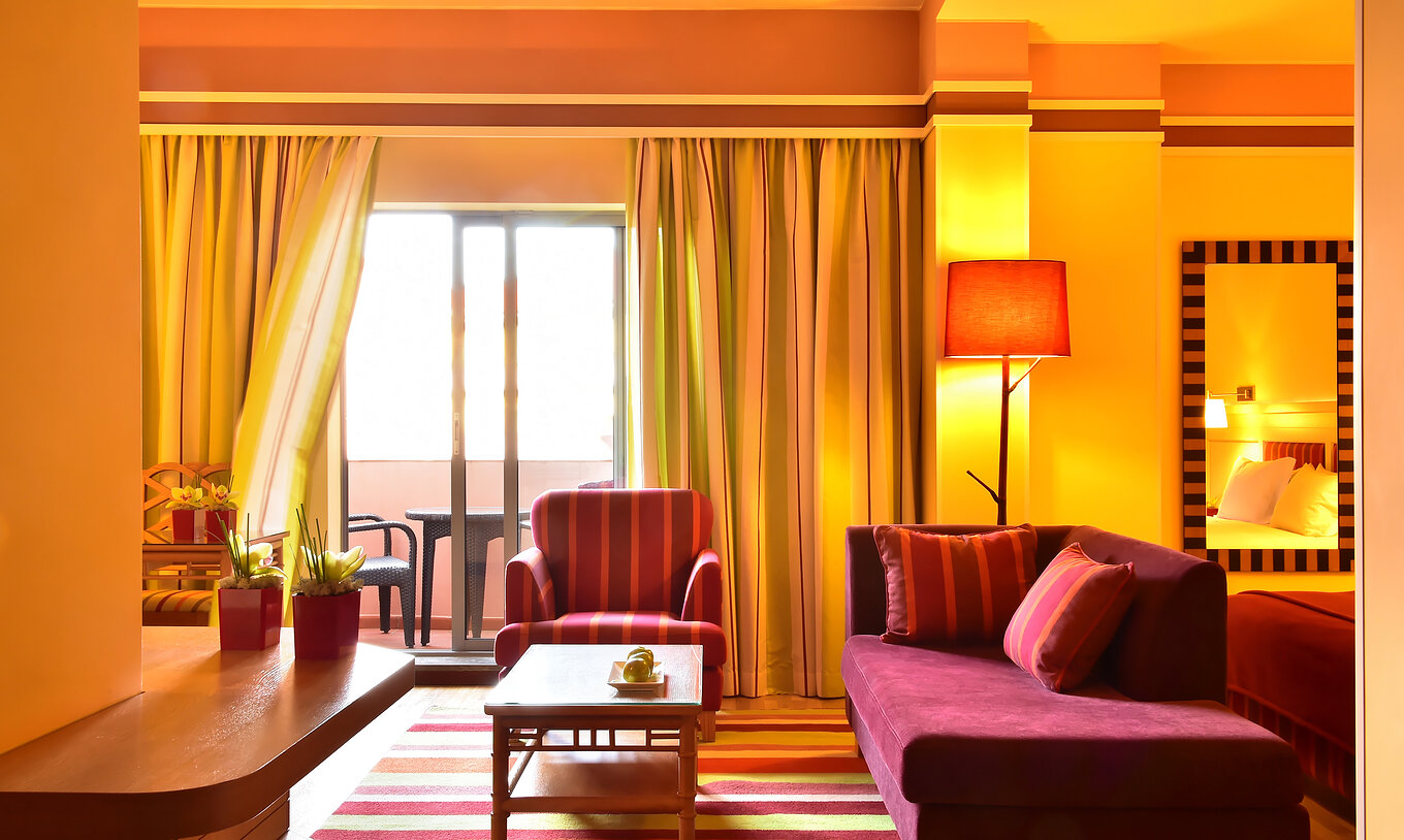 The Junior Suite of Pestana Sintra Golf has two sofas, a coffee table, and a window with access to the balcony