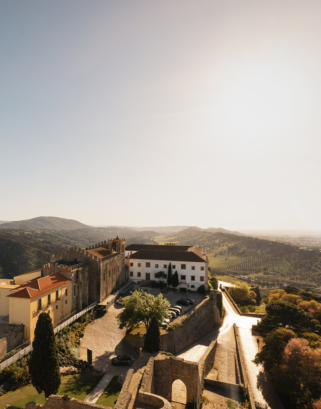 Panoramic view of Pousada Castelo Palmela, a hotel with a view of the Serra da Arrábida, with a castle with walls and towers