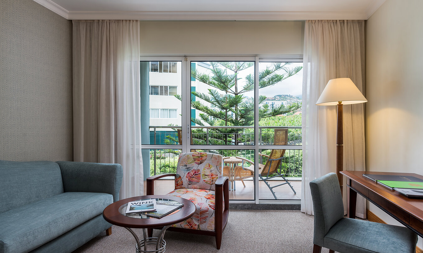 The Classic Sea Side Room at Pestana Grand has a sofa, armchair and a desk