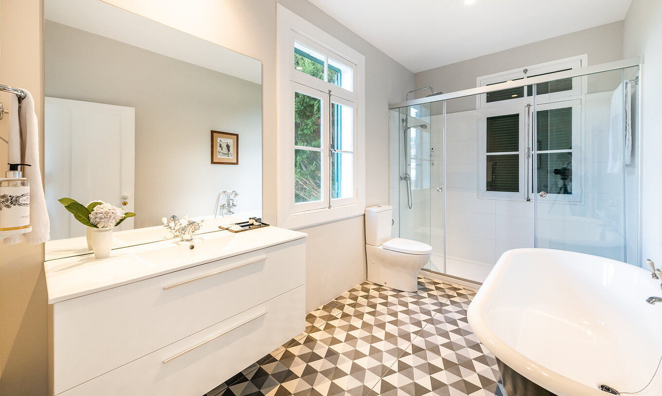 The Manor House - 1 of Pestana Quinta do Arco has a bathroom with bathtub and shower, sink with large mirror, and window