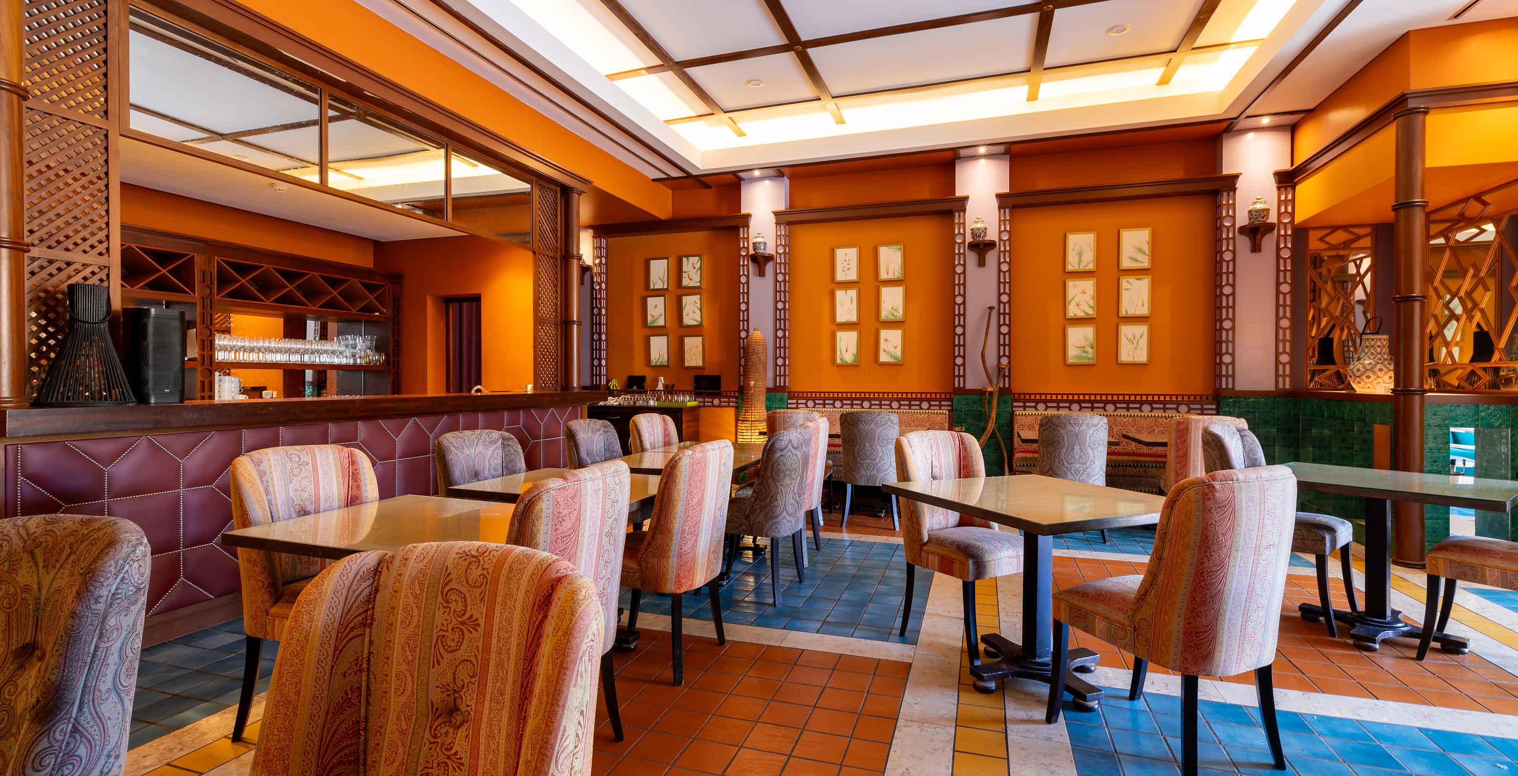 The Arab Magrebe restaurant at the 5-star Resort in Porto Santo features warm tones, square tables, and upholstered chairs.