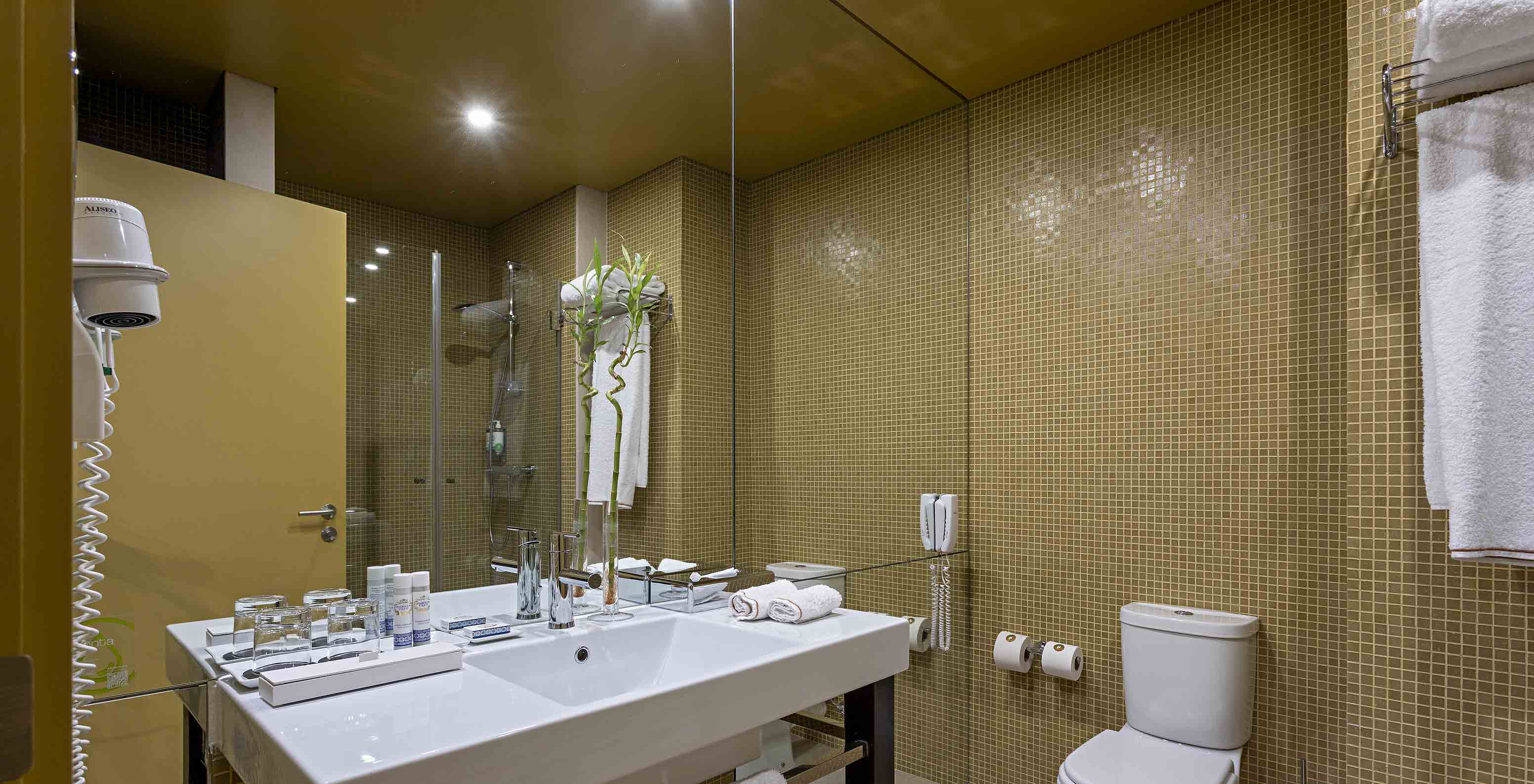 Pestana Palácio do Freixo’s Loft Attic has a bathroom with yellow tiles, toilet and washbasin