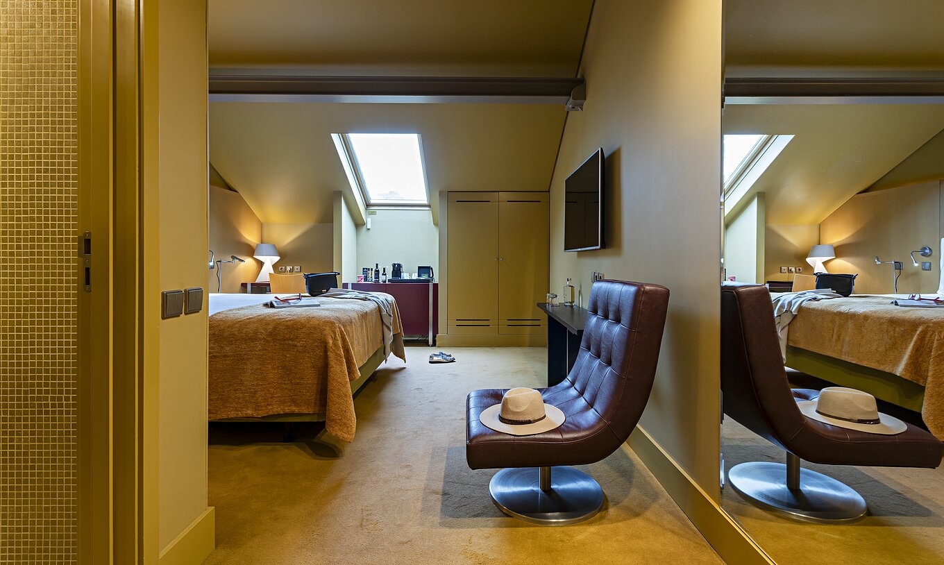 Pestana Palácio do Freixo’s Classic Attic has a double bed, a wardrobe, and a leather armchair