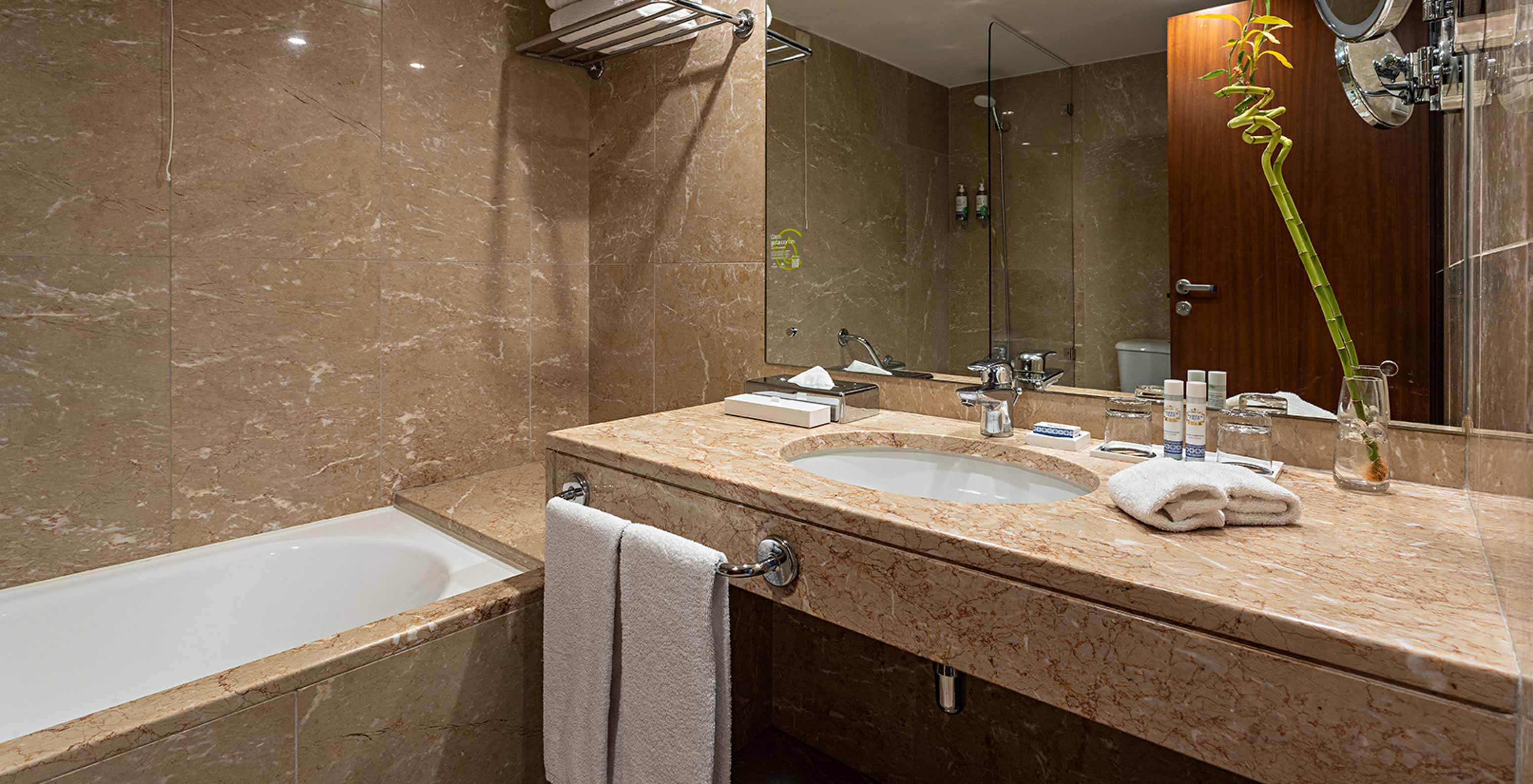 The Vintage River View at Pestana Vintage Porto has a brown marble bathroom with a sink and a bathtub