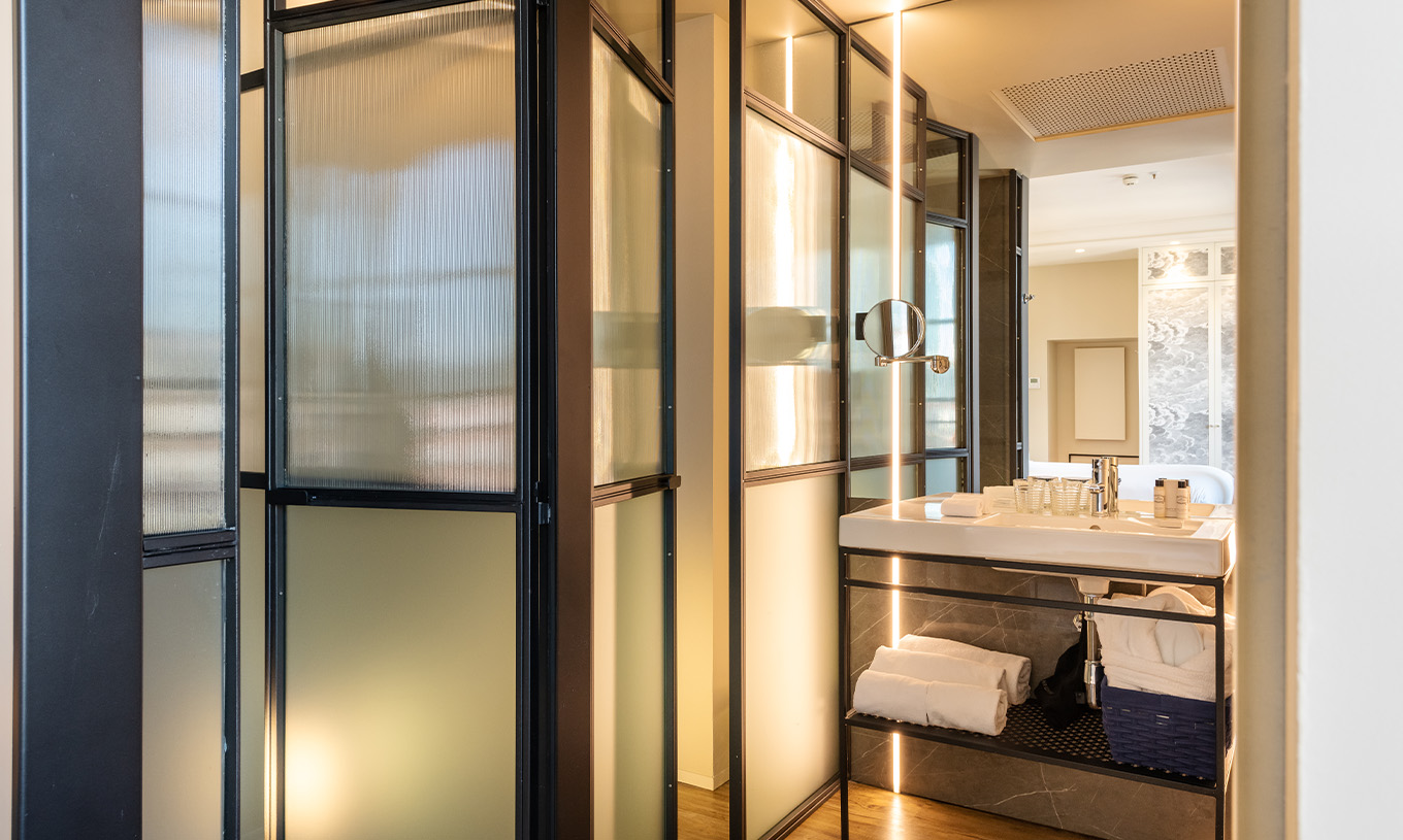 The Deluxe Grand Plaza Mayor at Pestana Plaza Mayor Madrid has a bathroom with sink with mirror and towels