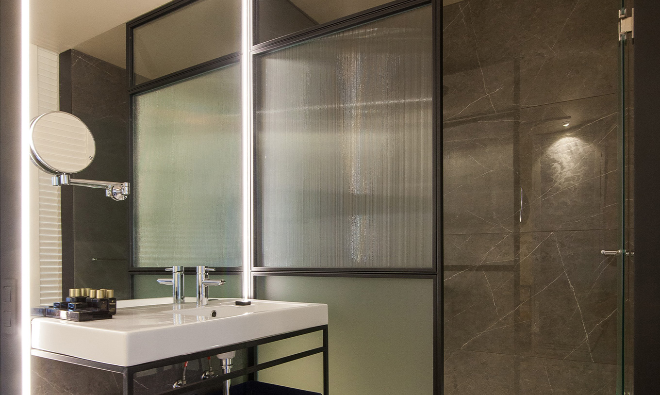 The Superior room at Pestana Plaza Mayor Madrid has a bathroom with a walk-in shower, a magnifying mirror and amenities