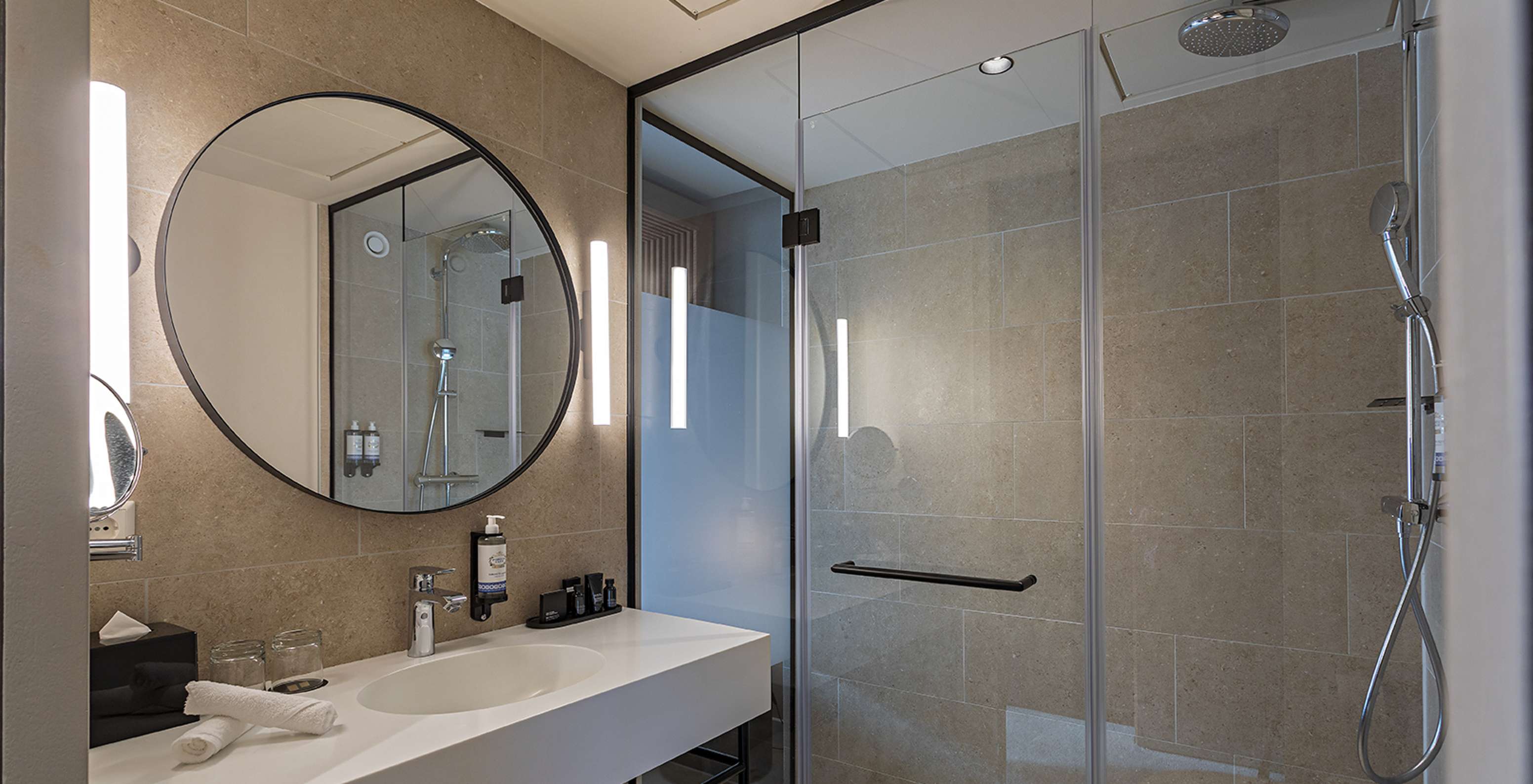 Superior room at Pestana Amsterdam Riverside has a bathroom with mirror, sink, towels and shower