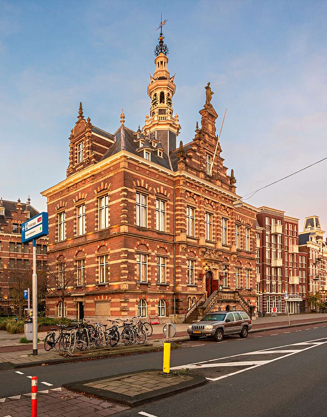 Exterior view of Pestana Amsterdam Riverside, with red bricks, parked bicycles, and a clear sky