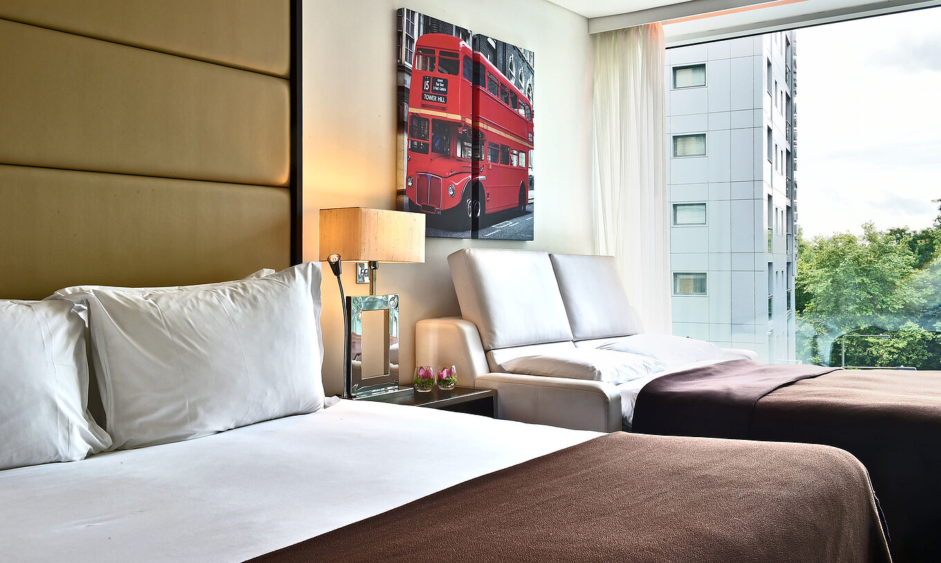 The Deluxe Family at Pestana Chelsea Bridge has a double bed, open sofa bed, London art and a window with view