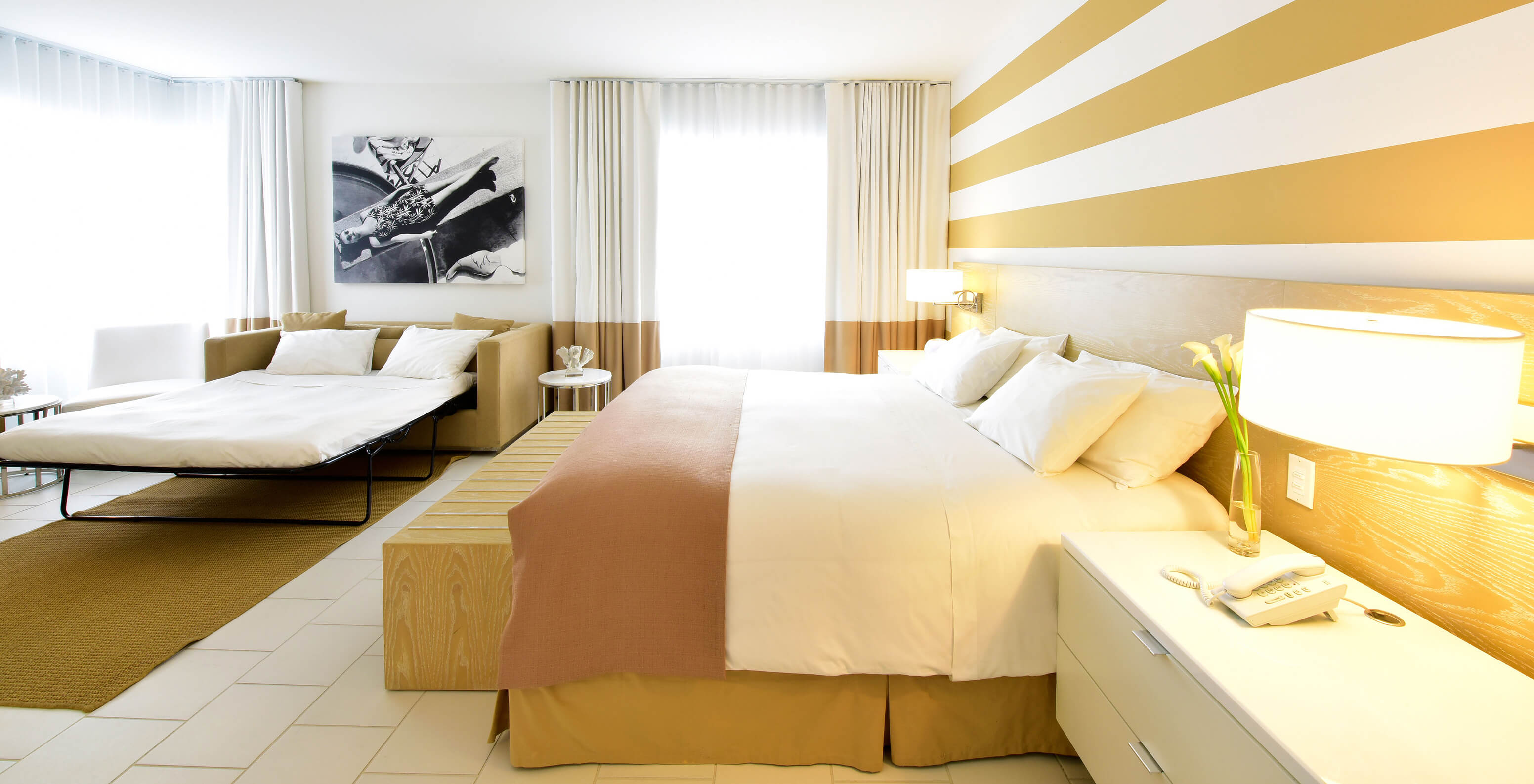 The Deluxe with Sofa Bed at Pestana Miami South Beach has a double bed, sofa bed, bedside table and lamp