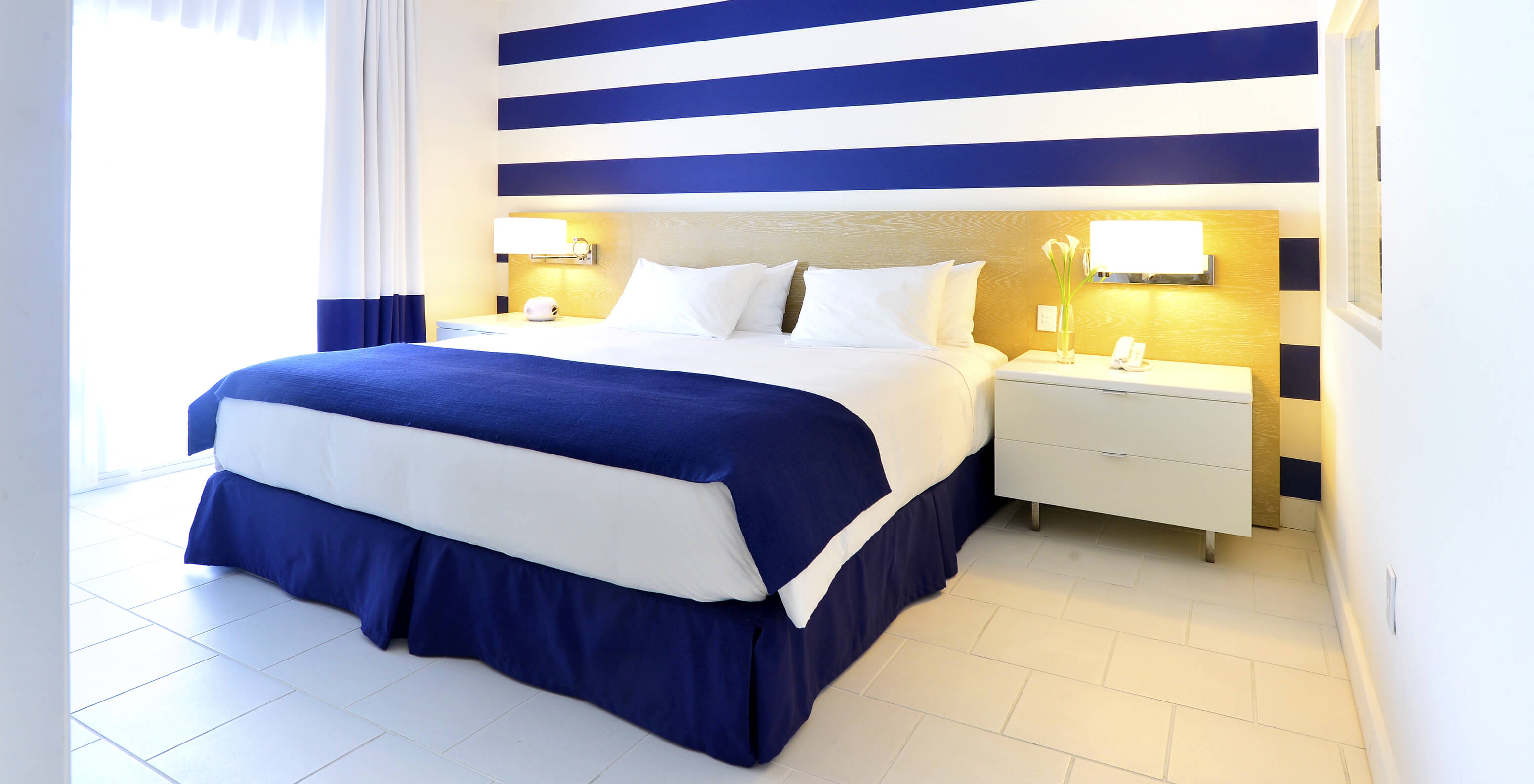 The Suite King with Balcony at Pestana Miami South Beach has a double bed, bedside table and lamp