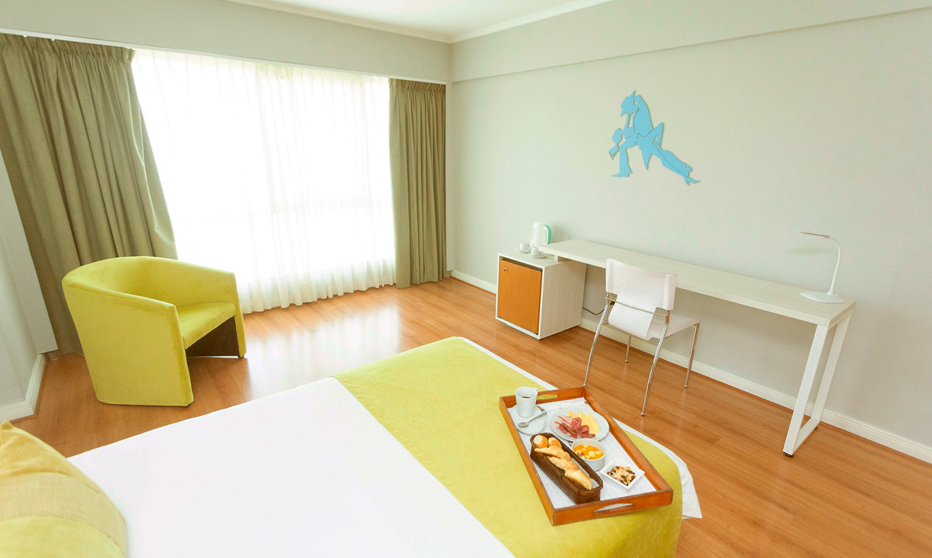 The Queen Executive Room at Pestana Buenos Aires has a chair, a desk, and decorative elements