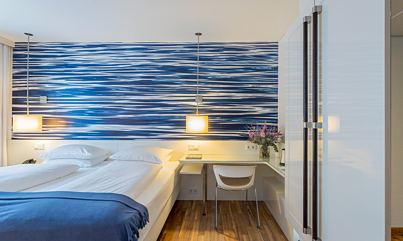 Deluxe Room with Terrace at Pestana Berlin Tiergarten has a double bed and a desk with lamp and chair