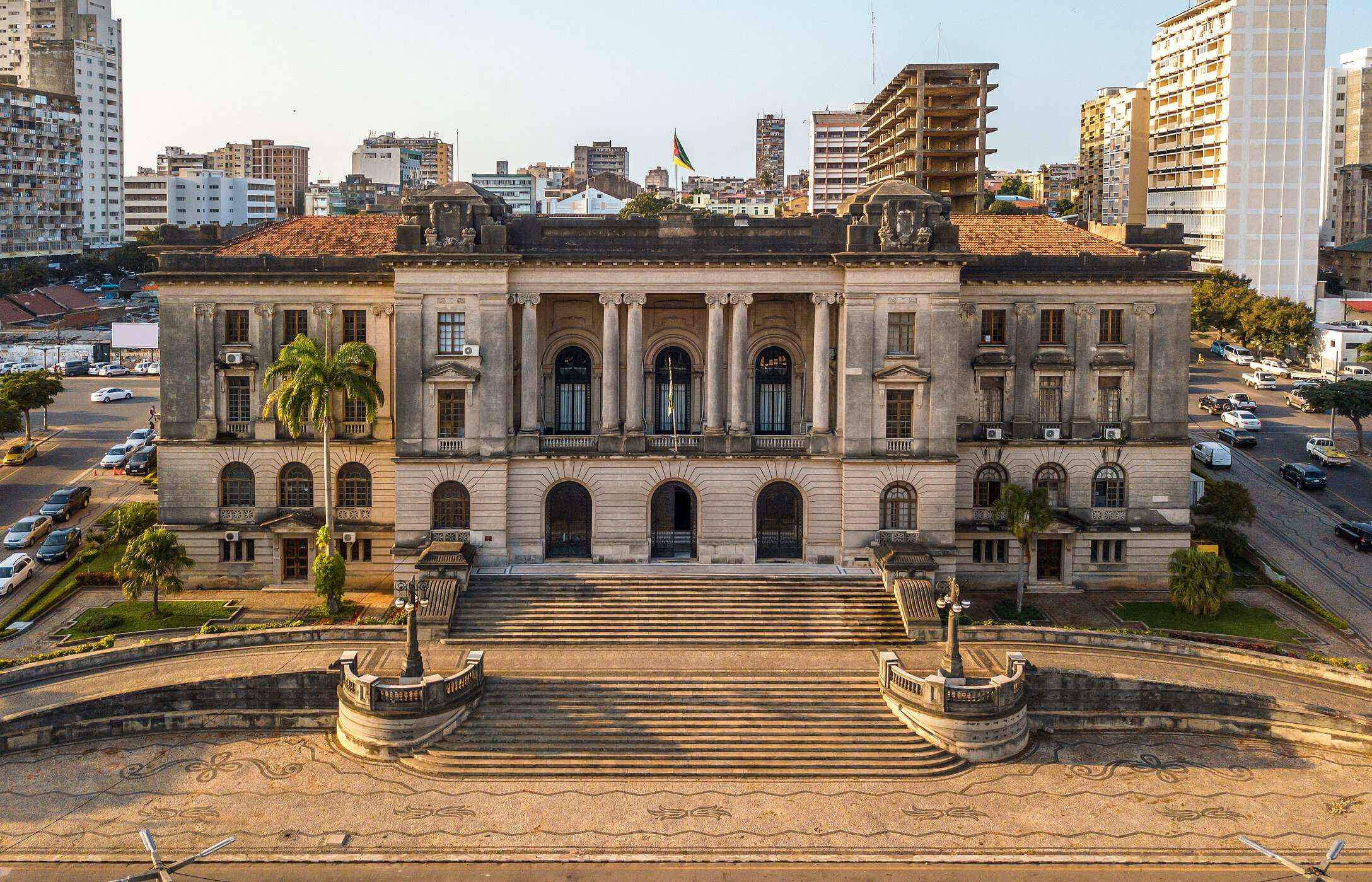 Aerial view of the Maputo City Hall building, with neoclassical architecture, surrounded by busy streets