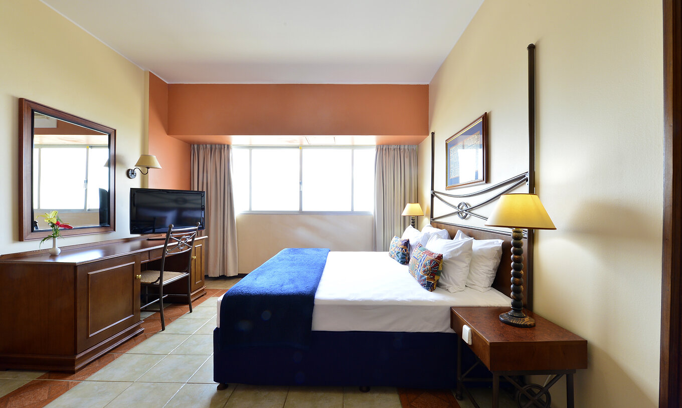 The Executive Suite of Pestana Rovuma has a double bed, desk with television, and a large window