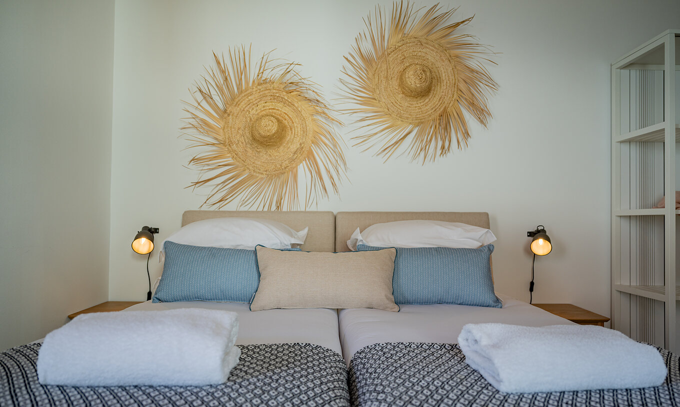 The Standard Villa T2 at Pestana Comporta Village Residences has a double bed with straw decoration on the wall