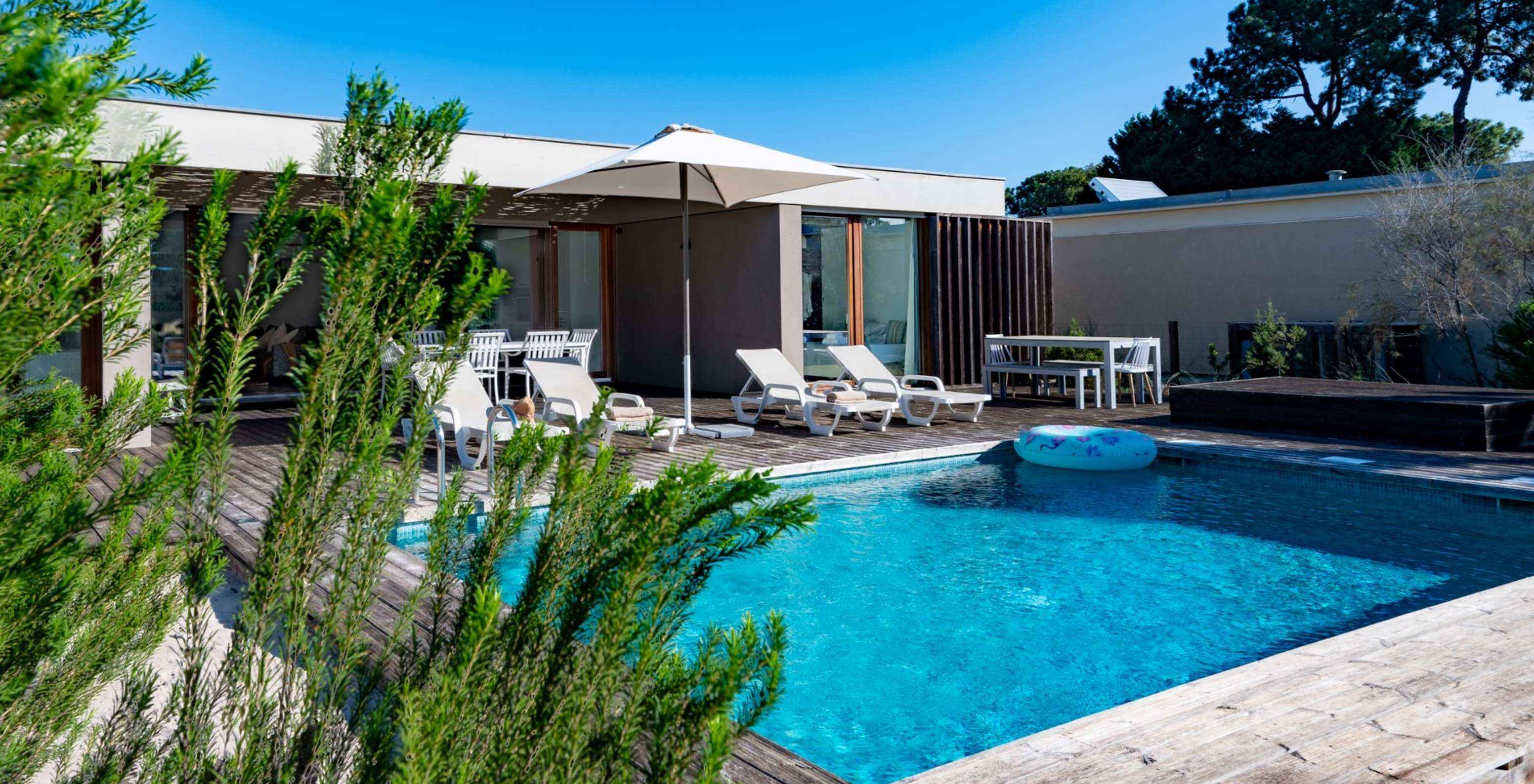 The 4-Bedroom Villas of Pestana Tróia Eco Resort have several sun loungers, a sun umbrella, and a float