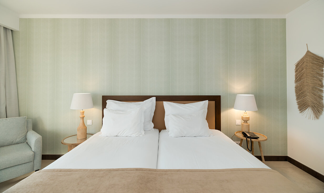 Studio Garden View at Pestana Alvor Beach Villas has two beds with bedside table and green wallpaper