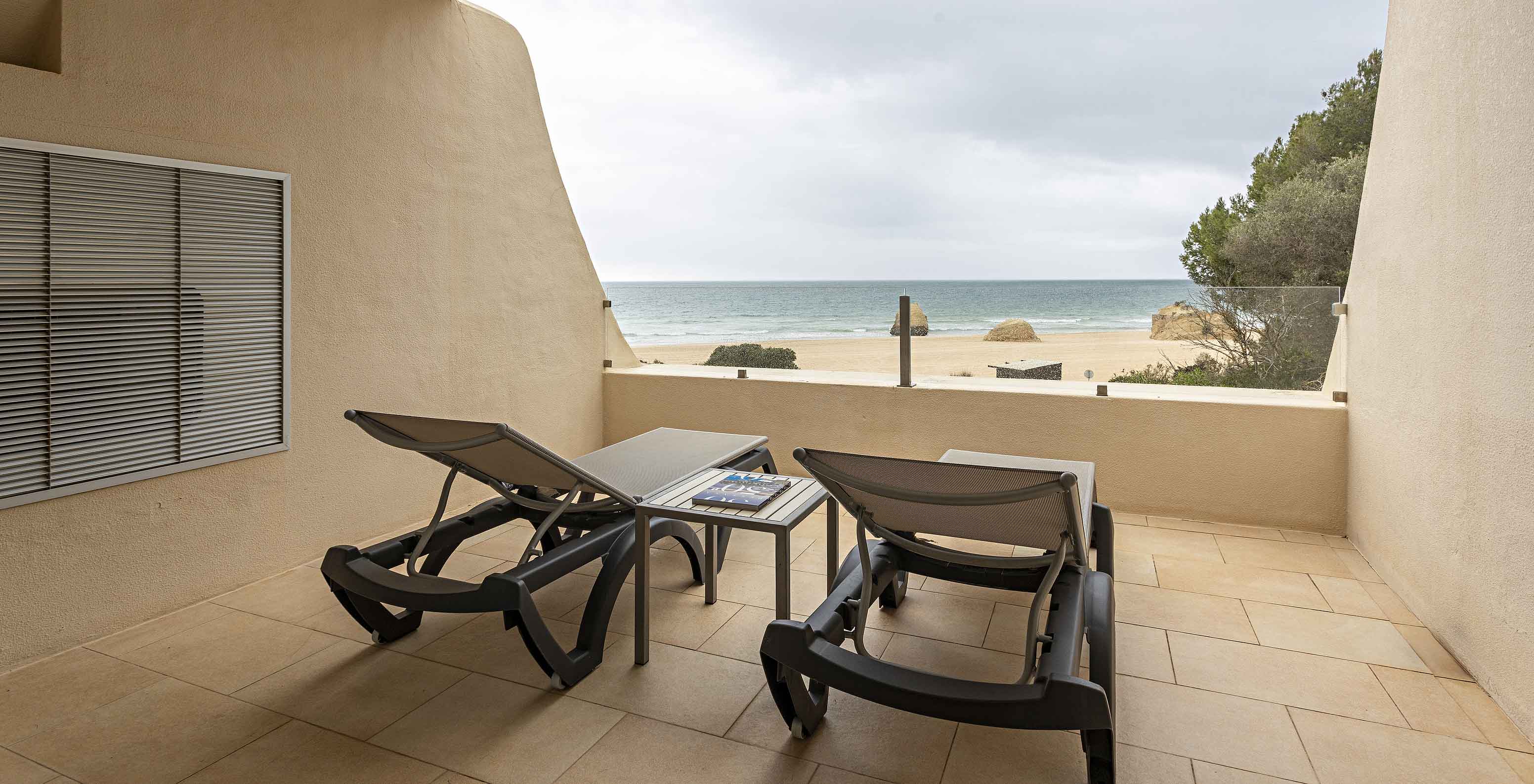 The Cliff Suite T1 at Pestana Alvor Praia has a balcony with two loungers and a view of the beach