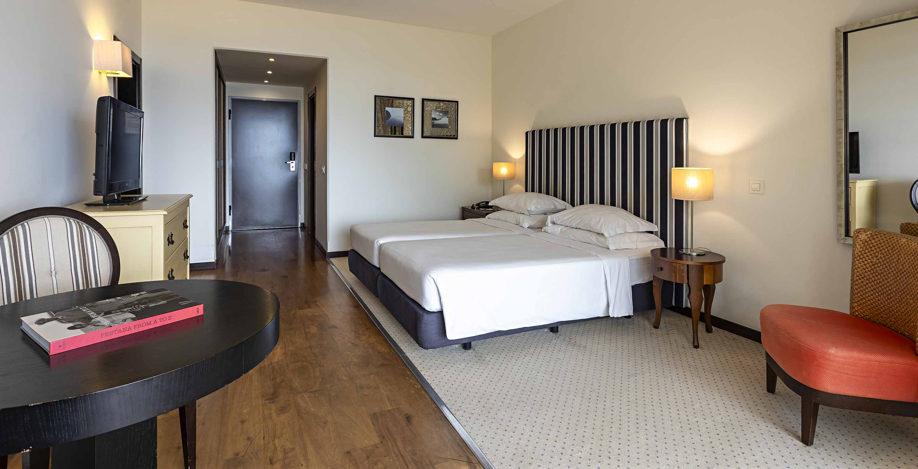 The Cliff Suite T1 at Pestana Alvor Praia has a double bed, with a television, a mirror, a table, and a chair