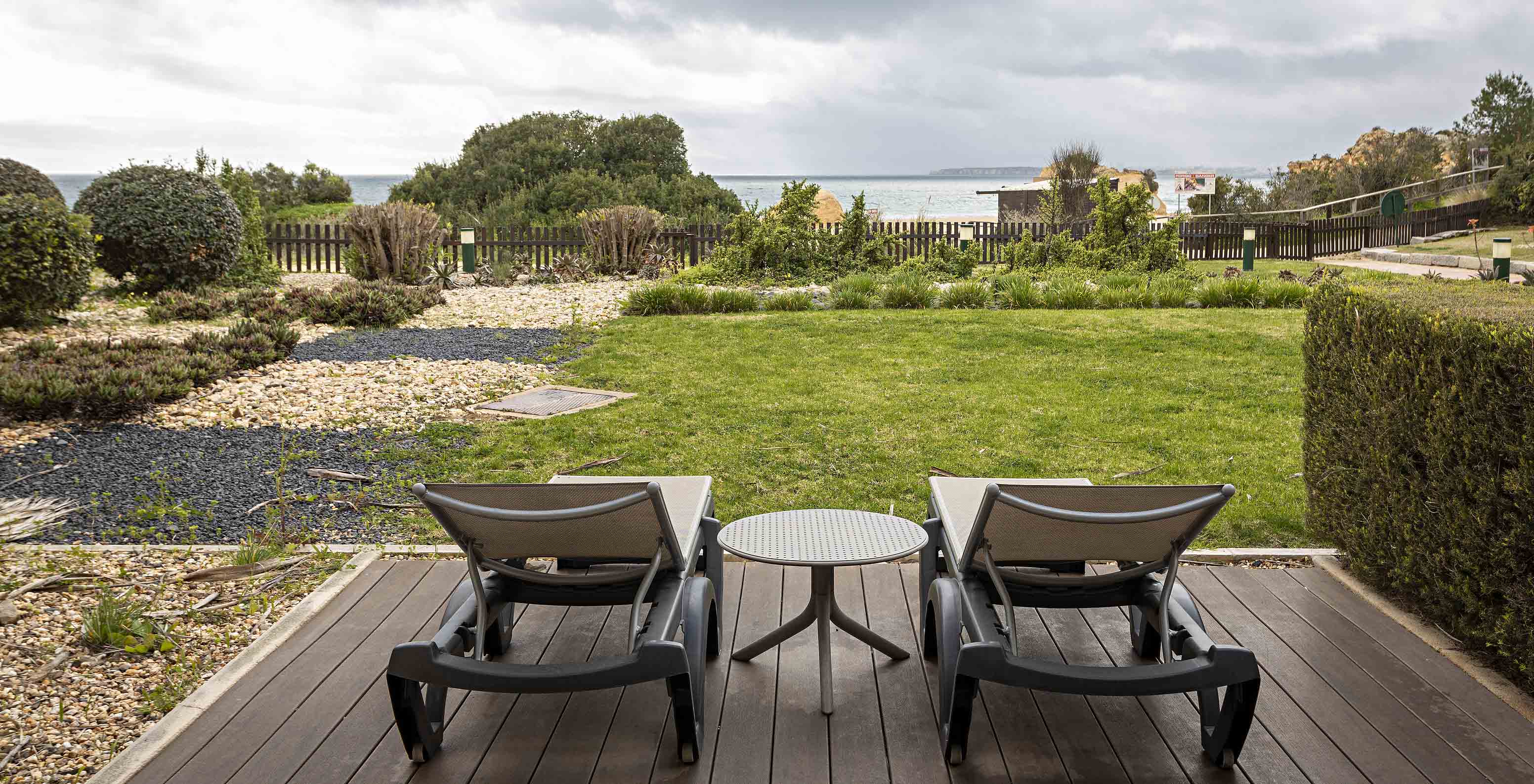 The Cliff Suite T2 at Pestana Alvor Praia has a garden with grass and vegetation, two sun loungers, and a view of the beach