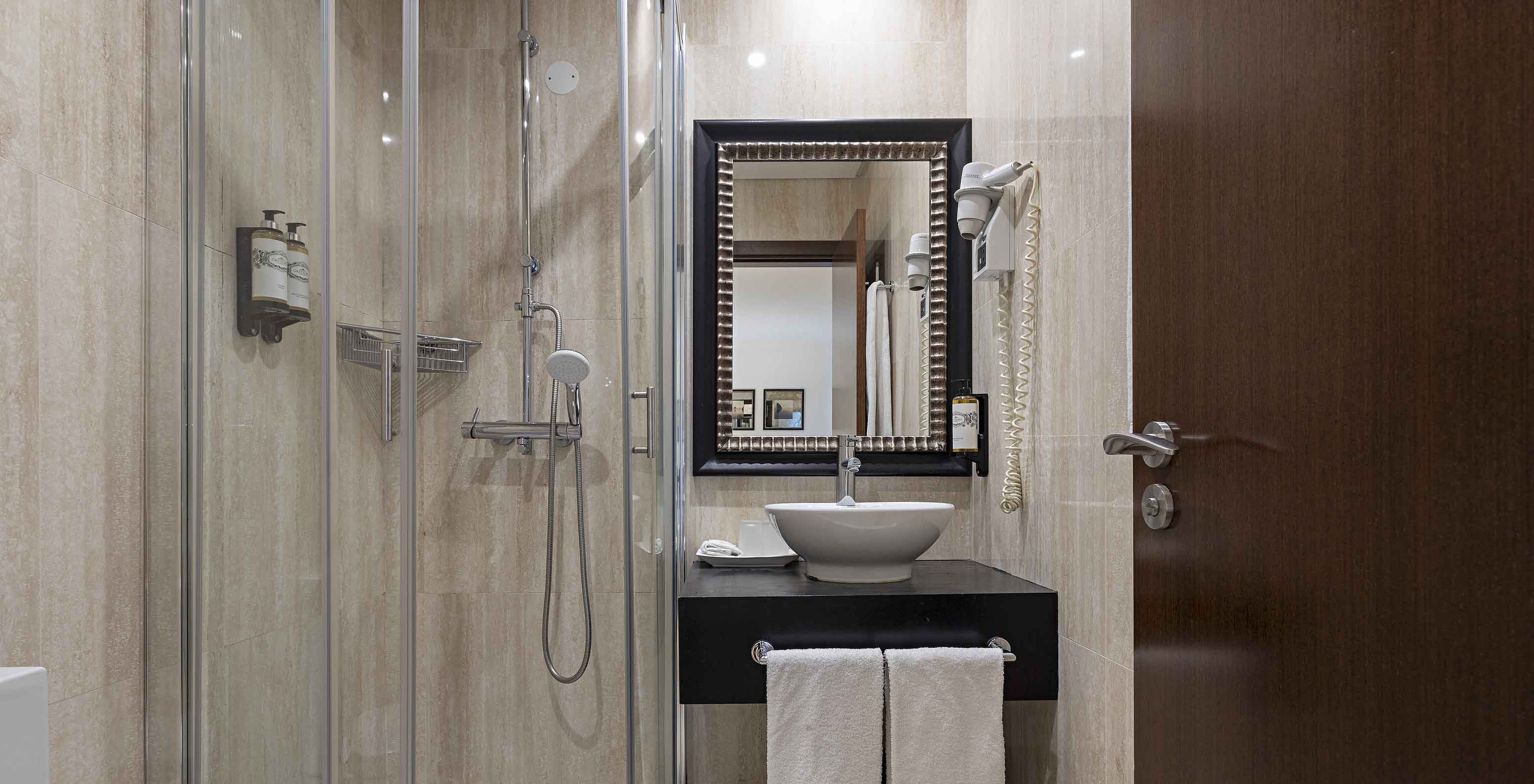 The Cliff Suite T2 at Pestana Alvor Praia has a bathroom with a shower, a sink, a hairdryer, and a mirror