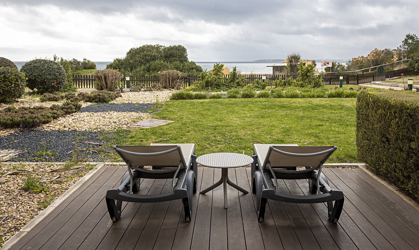 The Cliff Suite T2 at Pestana Alvor Praia has a garden with grass and vegetation, two sun loungers, and a view of the beach