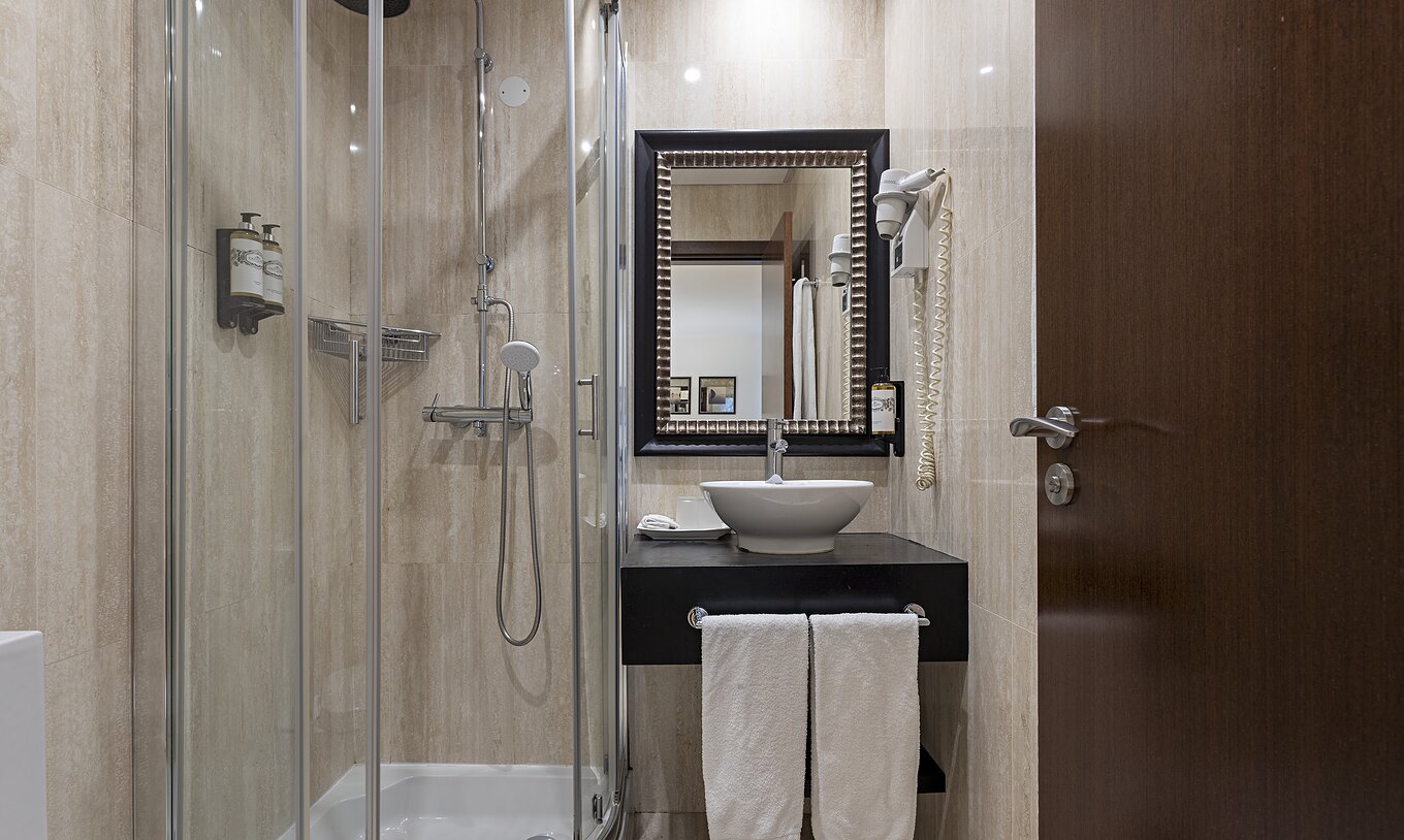 The Cliff Suite T2 at Pestana Alvor Praia has a bathroom with a shower, a sink, a hairdryer, and a mirror