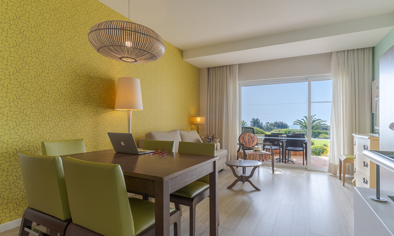 The Duplex Sea View Suite T1 at Pestana Alvor Praia has a living room with a dining table and a balcony
