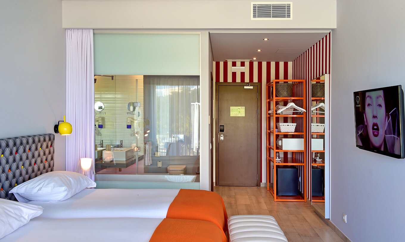 The Deluxe Pool View of Pestana Alvor South Beach has a bathroom with bathtub and window to the room