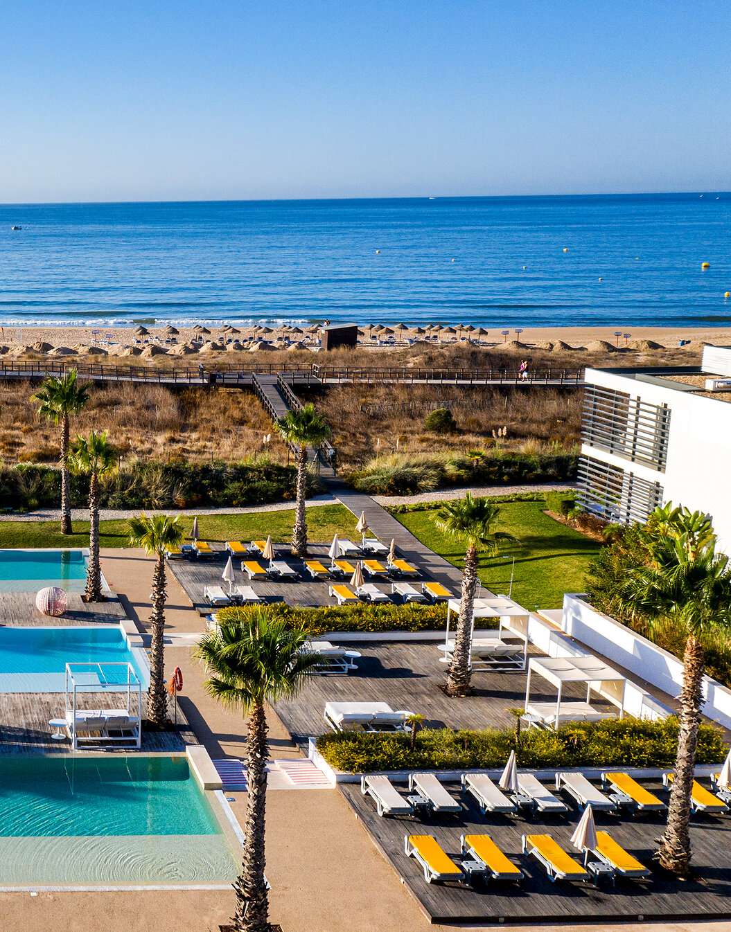Outdoor area of the pools and sun loungers at Pestana Alvor South Beach, with direct access to the beach