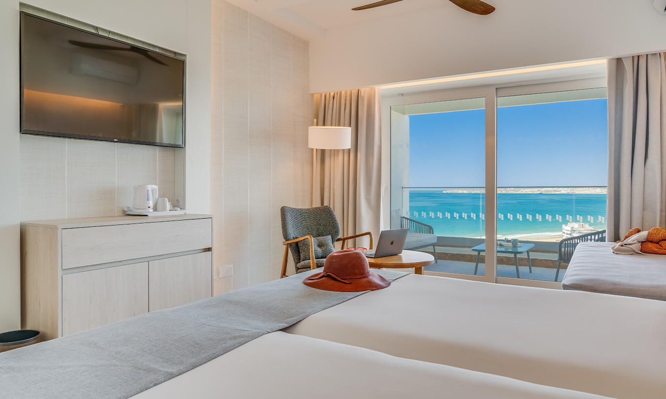 The Family Room at Pestana Blue Alvor Beach has two beds with white sheets and a TV at the end of the bed