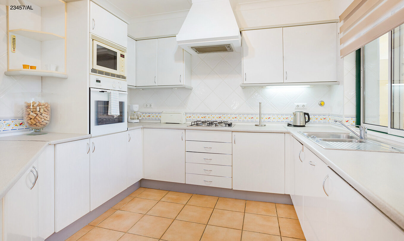 The Pestana Carvoeiro Golf T3 Standard Apartment has a kitchen with white cabinets and a countertop