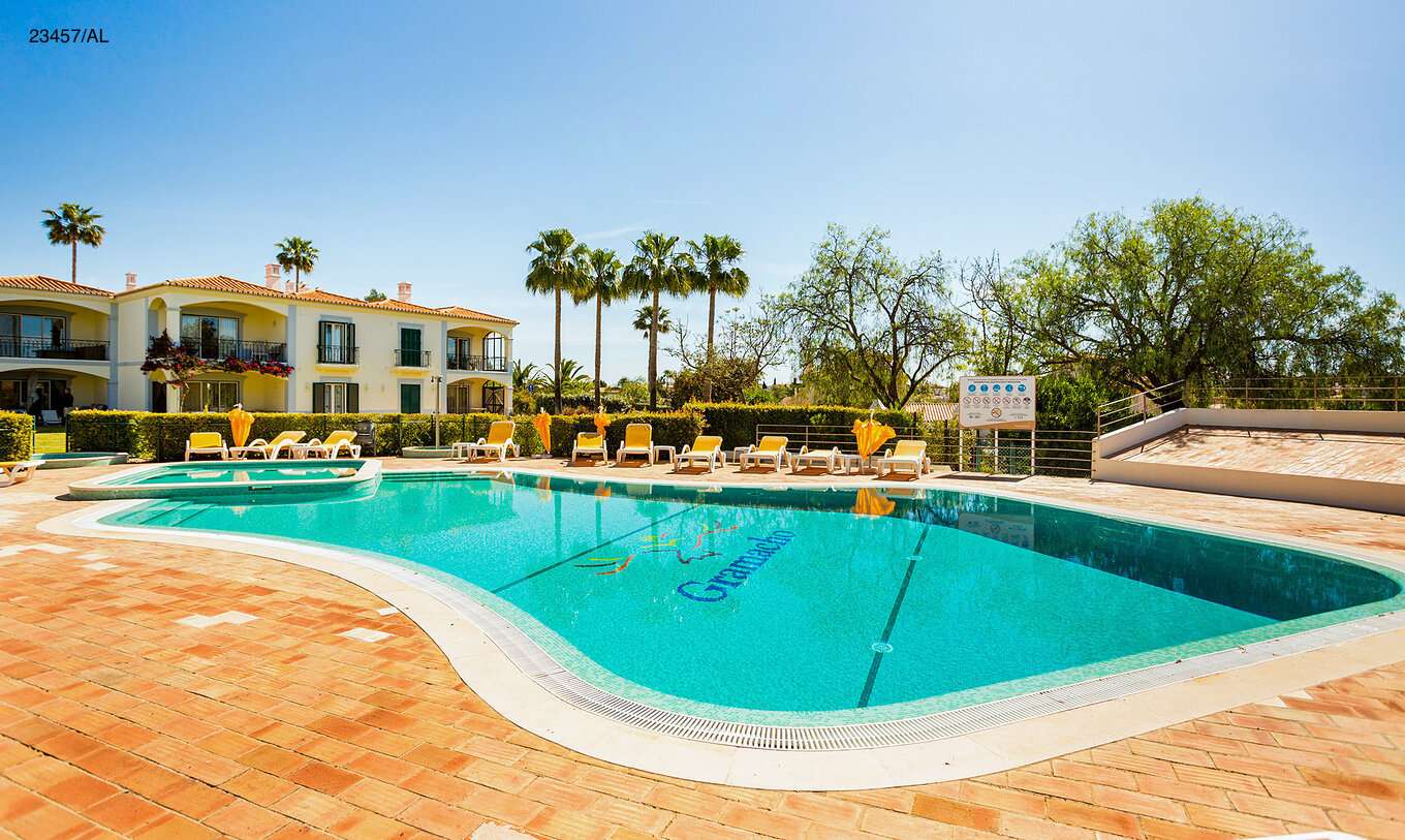 The Pestana Carvoeiro Golf T3 Standard Apartment has an exterior patio with a pool and yellow loungers