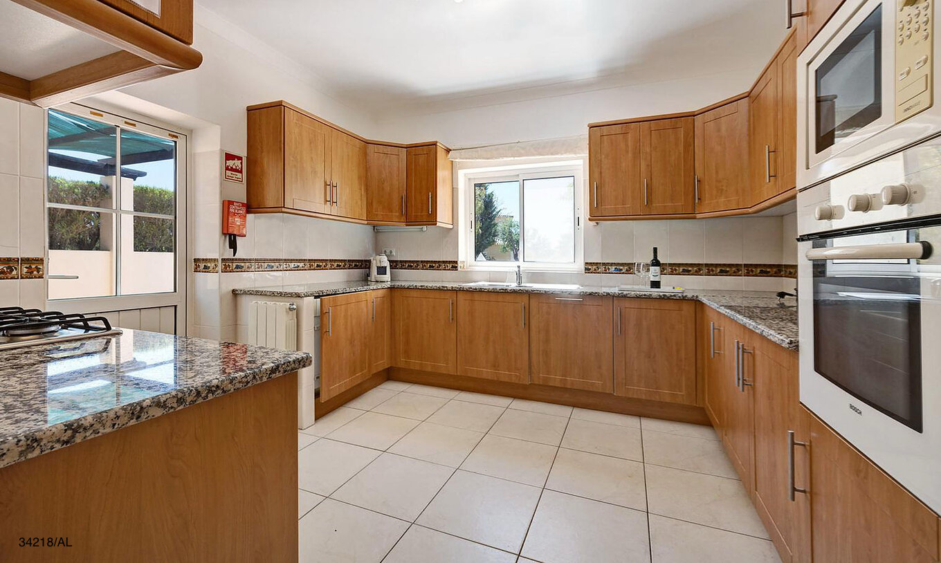 The Pestana Carvoeiro Golf V4 Standard Villa has a kitchen equipped with wooden cabinets and appliances