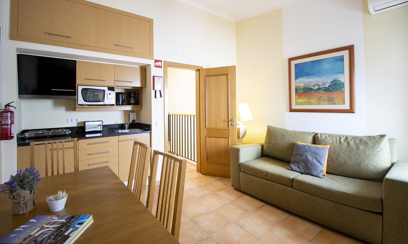 The T1 Apartment Land do Pestana Palm Gardens has a living room with a sofa, table and kitchenette with microwave