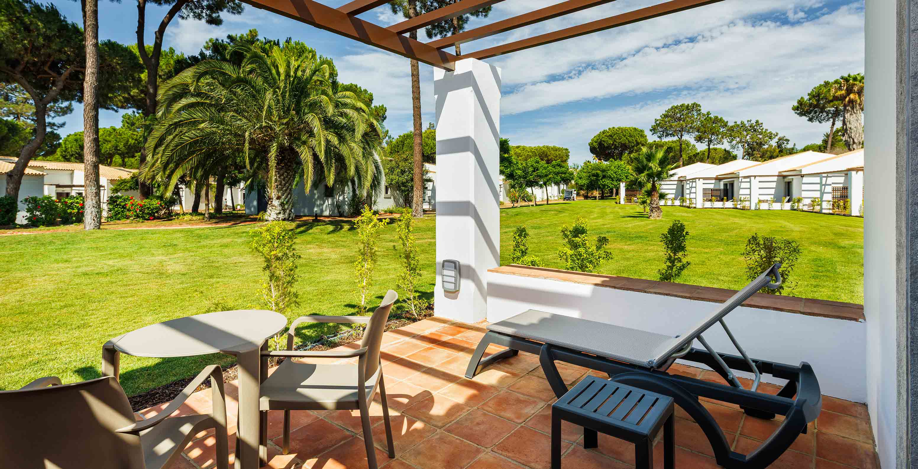 The Superior Garden View at Pestana Vila Sol - Vilamoura has a balcony with sun lounger, table and garden view