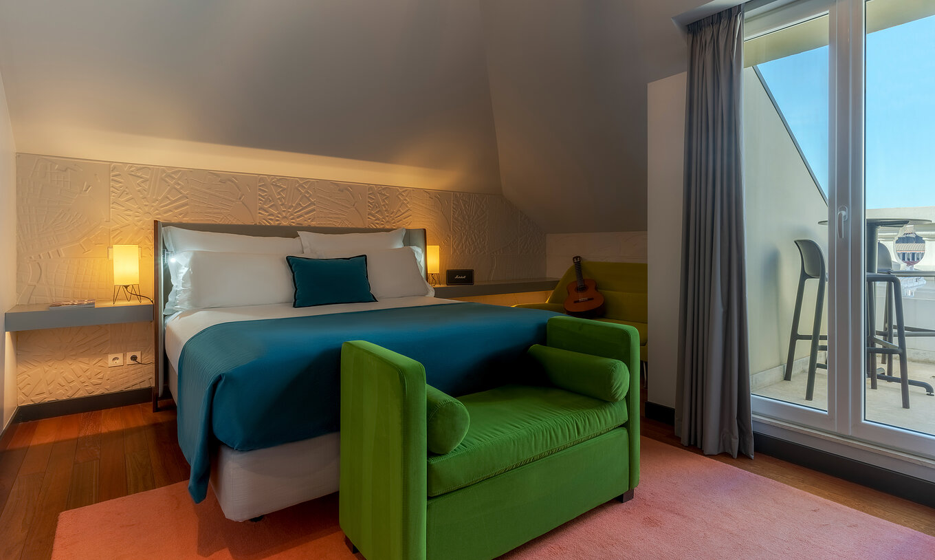 The CR7 Suite has a double bed a bench at the foot of the bed and a balcony at Pestana CR7 Lisboa