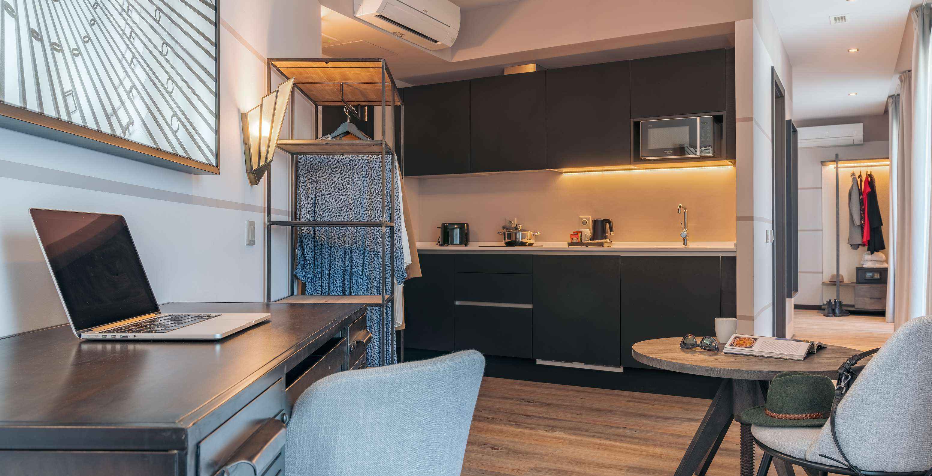 The Rooftop Junior Suite at Pestana Lisboa Vintage has an equipped kitchen, a table, a desk and a wardrobe with clothes
