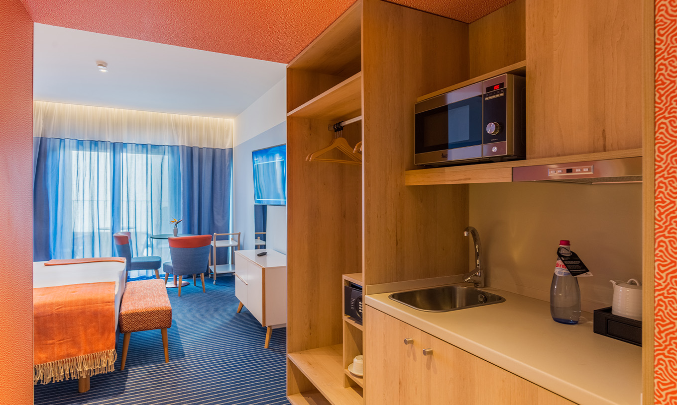 The Sea View Deluxe Studio at Pestana Casino Studios has a kitchen with a microwave and sink and a double bed