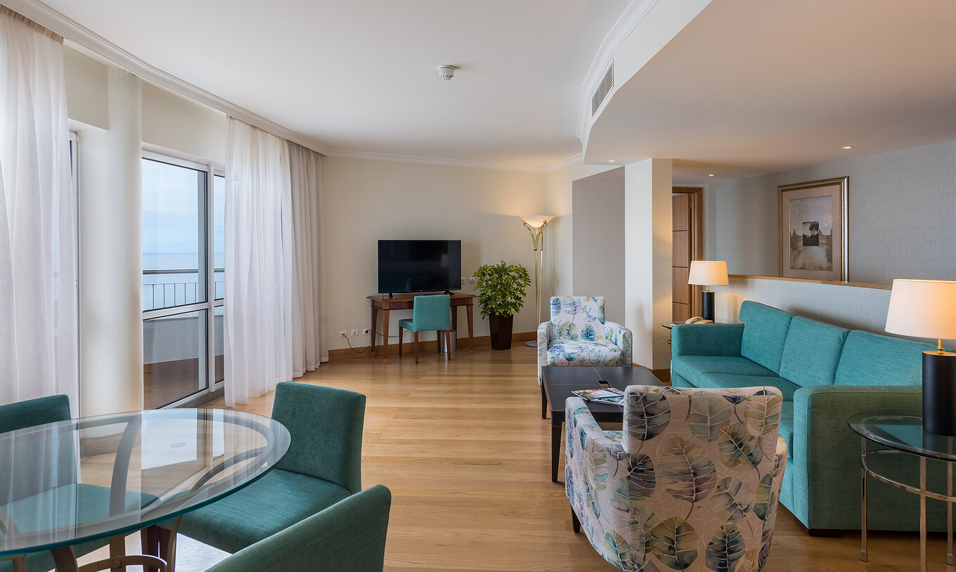The Master Suite Sea View at Pestana Grand has a living room, sofa with chairs and coffee table, and TV