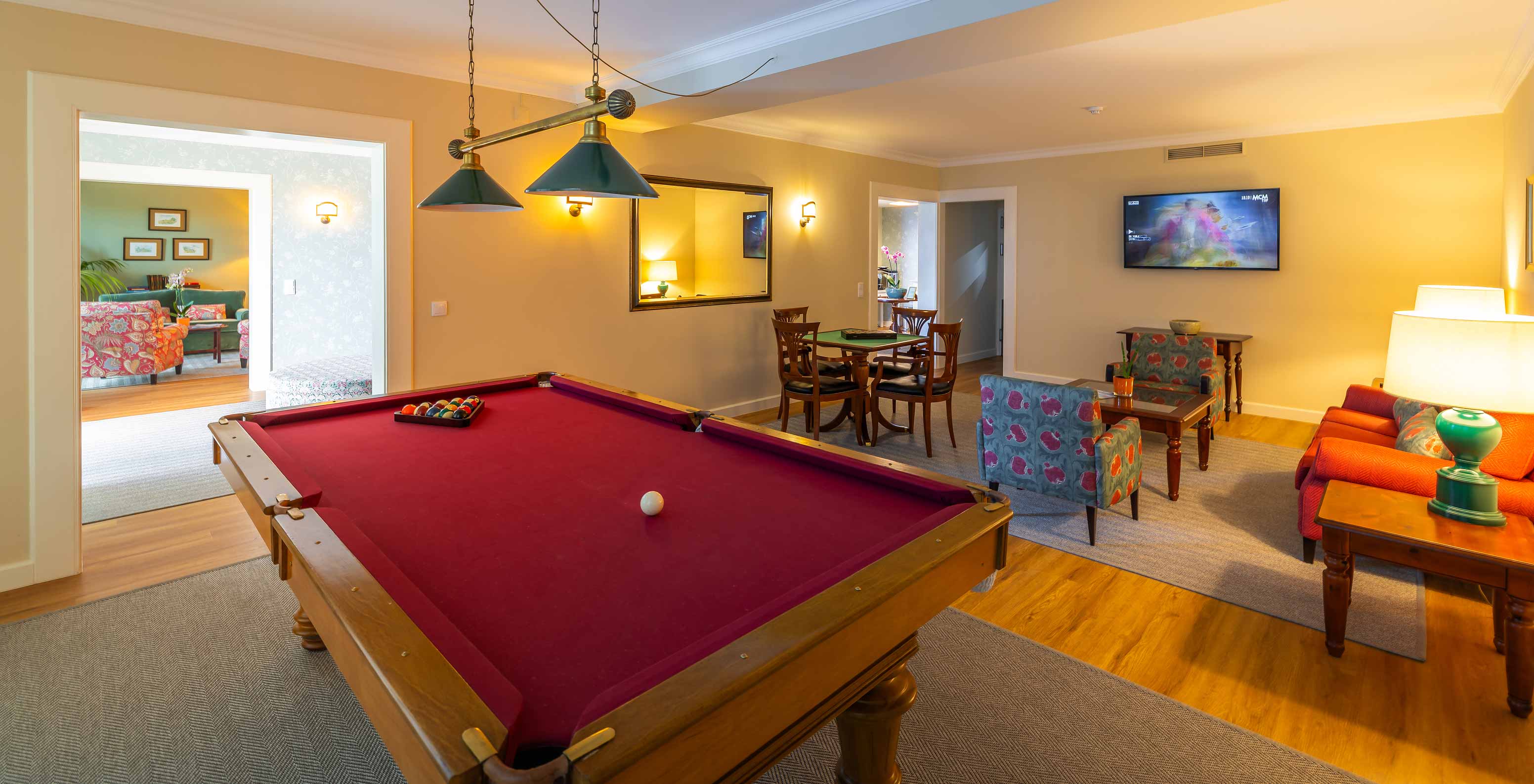 Games room of Pestana Quinta Perestrello with card table, sofa, and billiard table